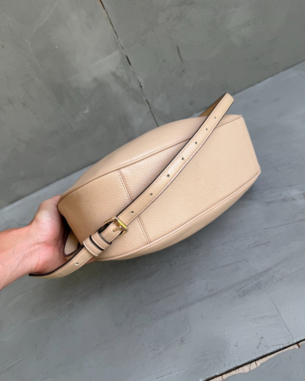 Coach Beige Leather Handbag-on a concrete background
