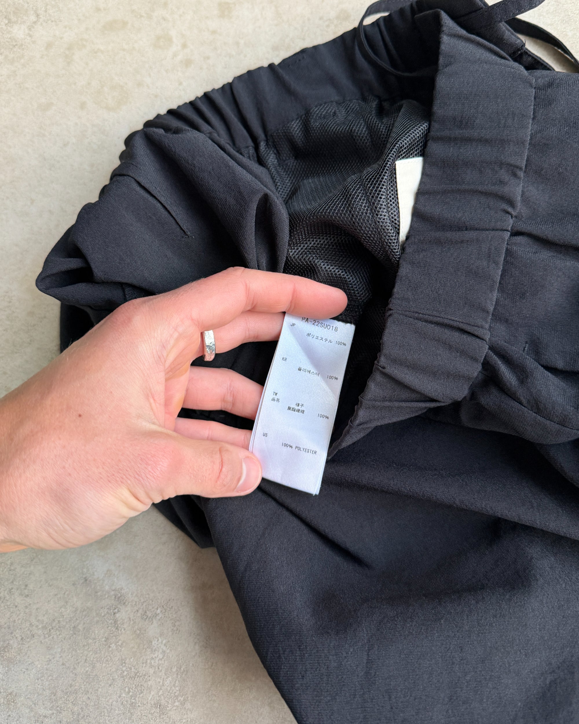 Snow Peak Black Trousers – S-on a concrete background