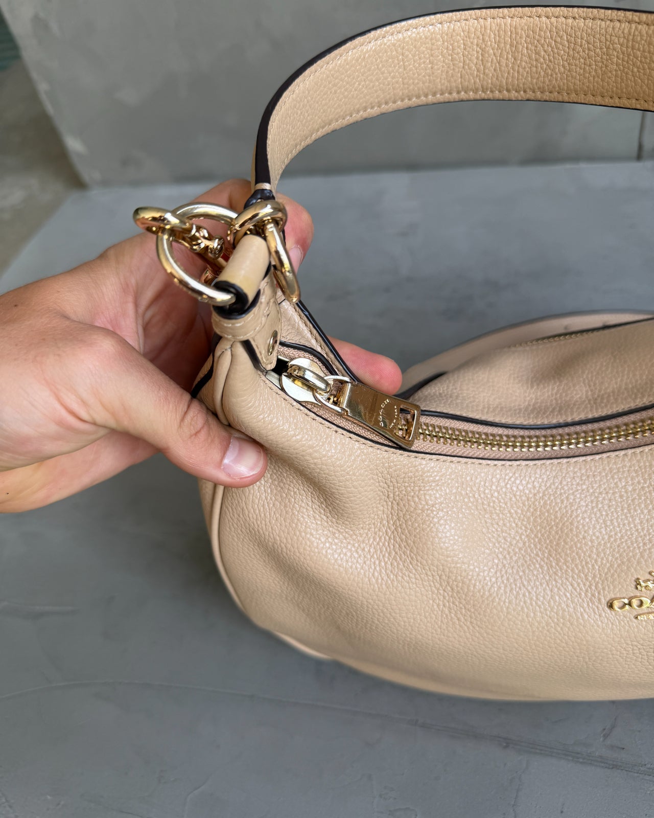 Coach Beige Leather Handbag-on a concrete background