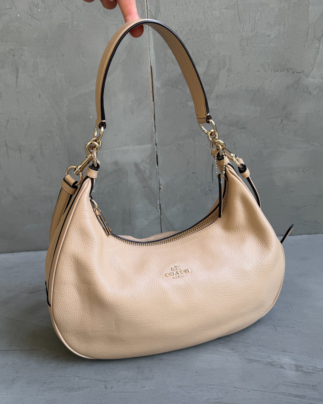 Coach Beige Leather Handbag-on a concrete background