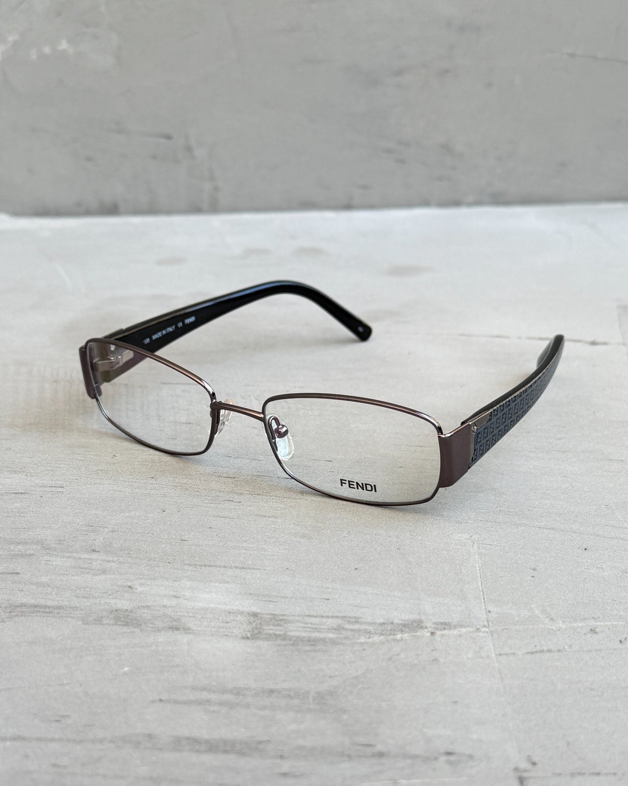 Fendi Clear Lens Gunmetal Frame Glasses-on a concrete background