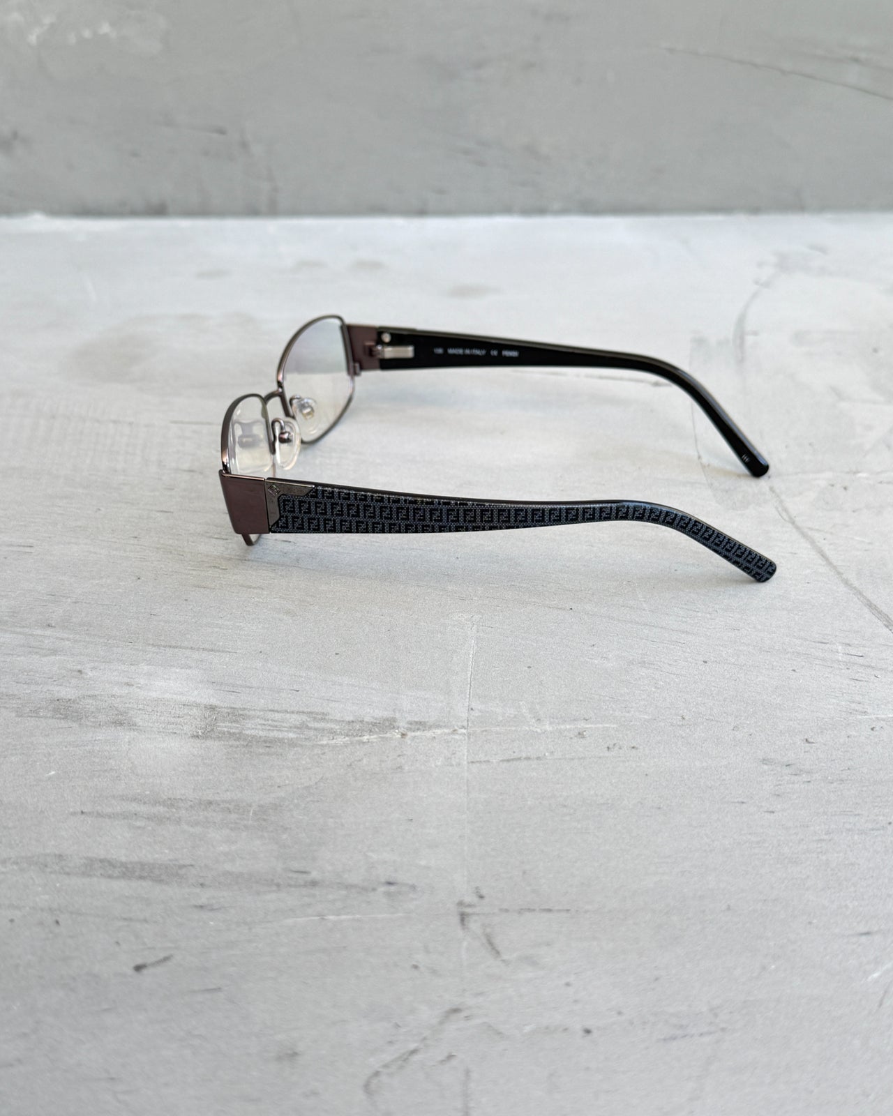 Fendi Clear Lens Gunmetal Frame Glasses-on a concrete background