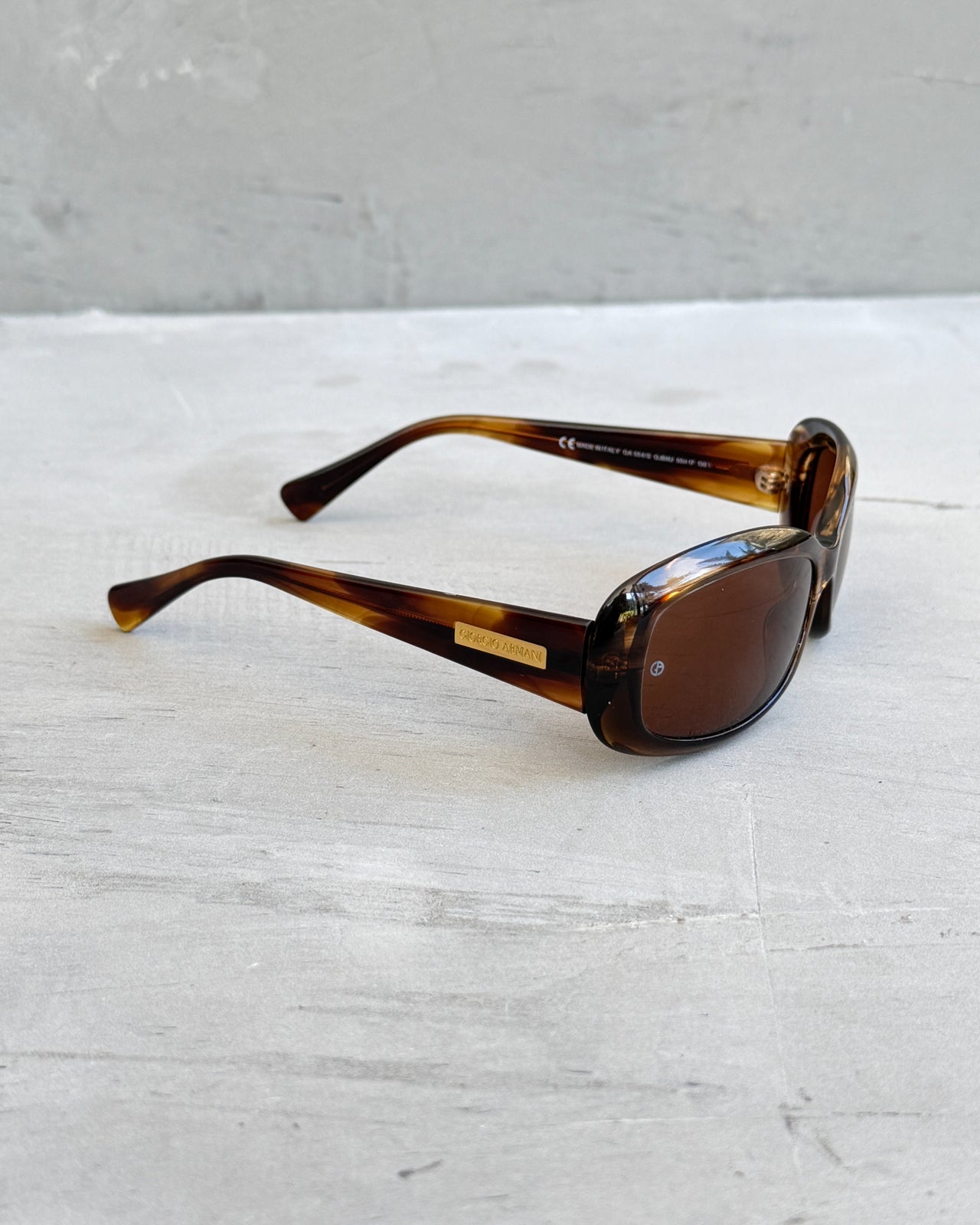 Giorgio Armani Oval Tortoiseshell Sunglasses-on a concrete background
