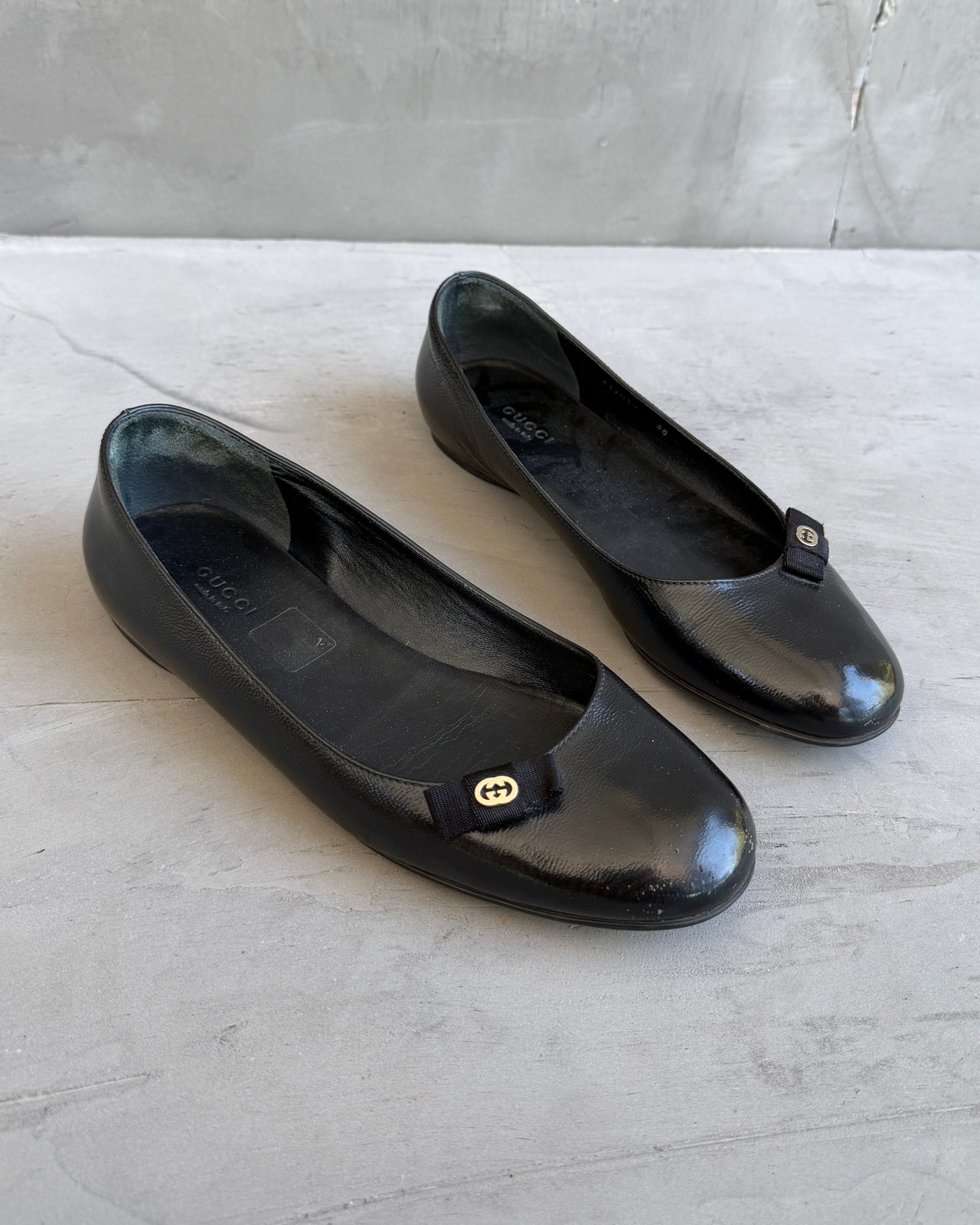 Gucci Black Leather Flats – EU 38-on a concrete background