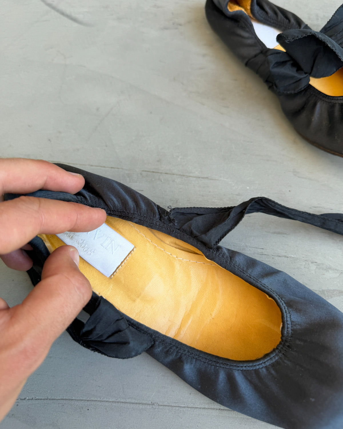 Lanvin Silk Ballet Flat with Ankle Tie-on a concrete background