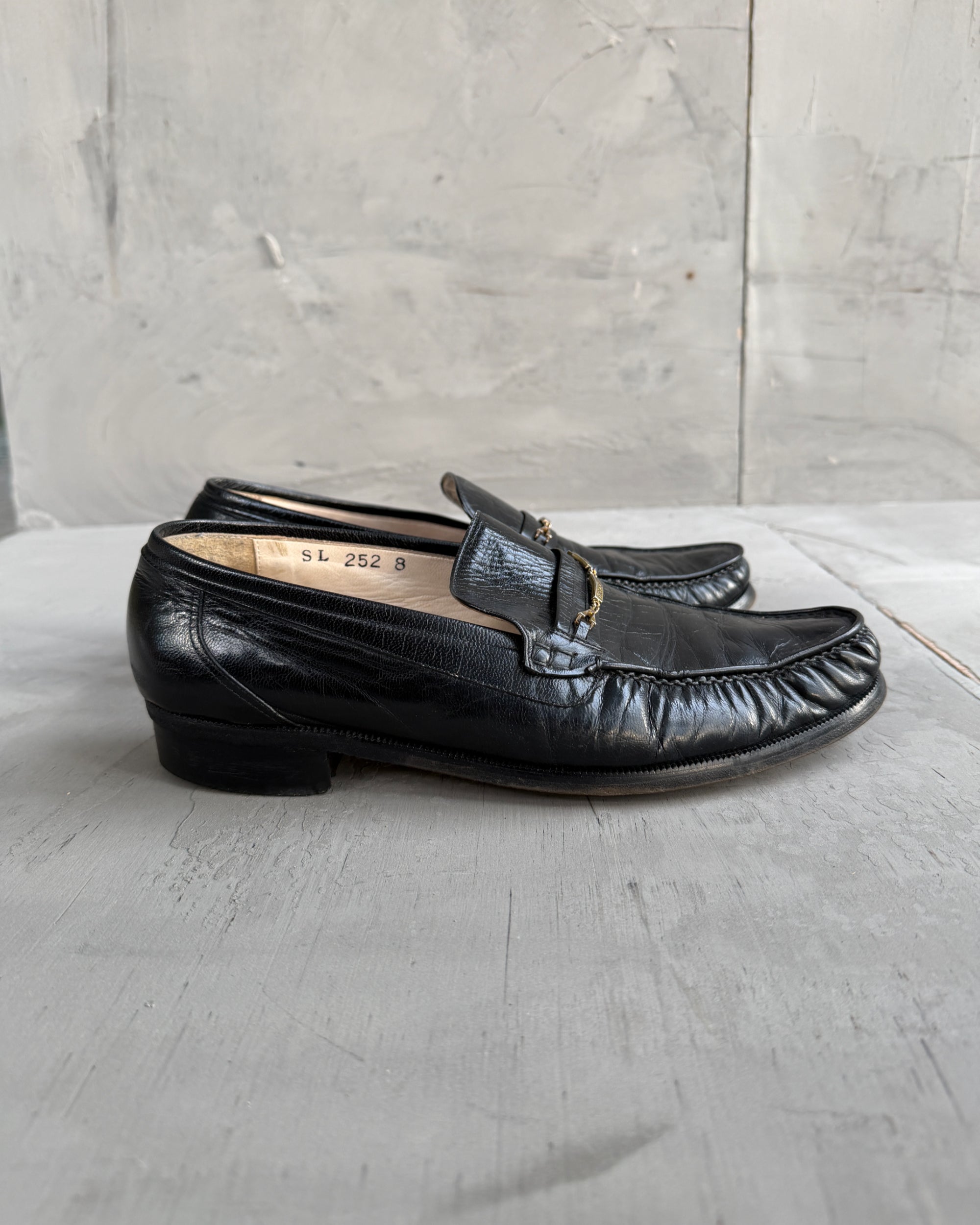 Yves Saint Laurent Black Leather Loafers – UK 8-on a concrete background