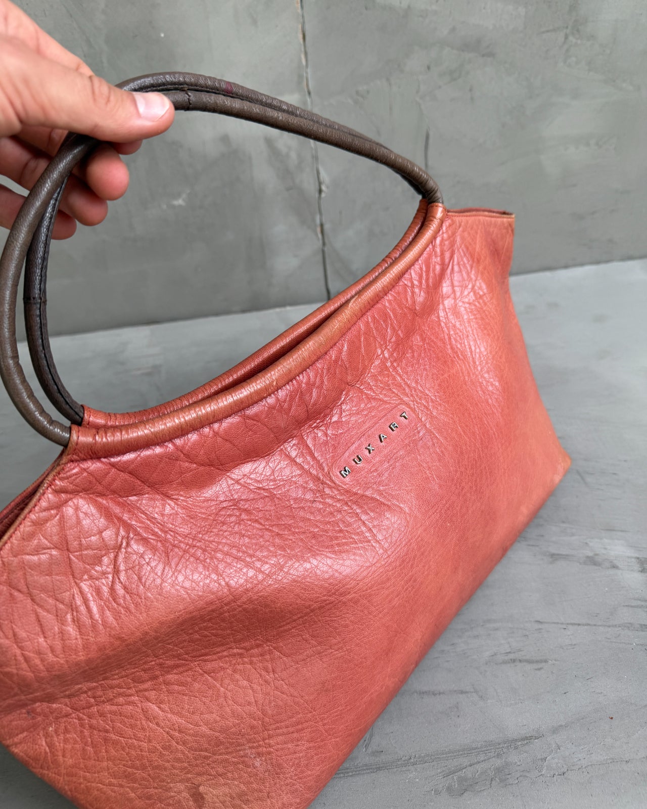 Muxart Leather Handbag-on a concrete background