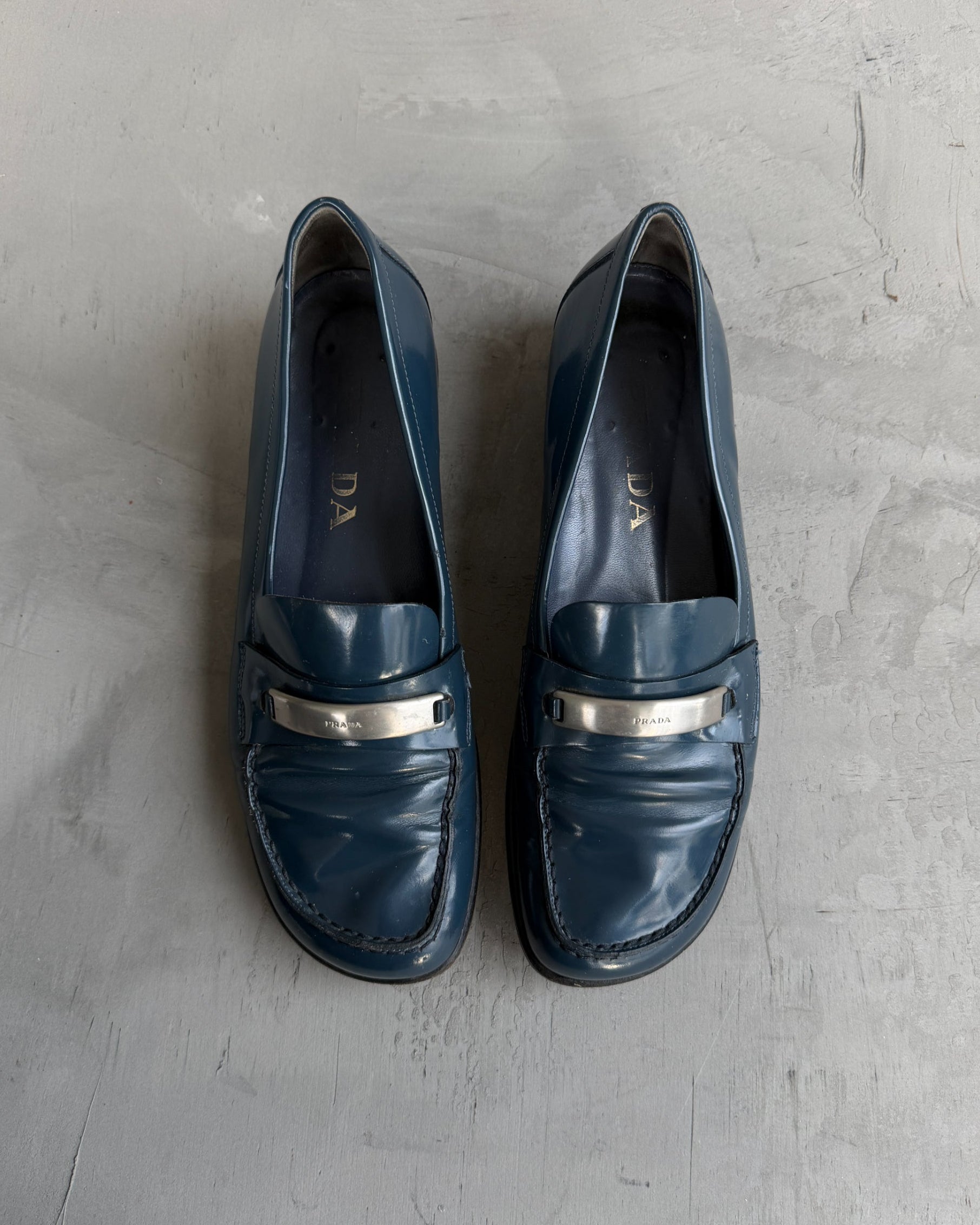 Prada Blue Leather Loafers with Silver Tab – EU 38-on a concrete background