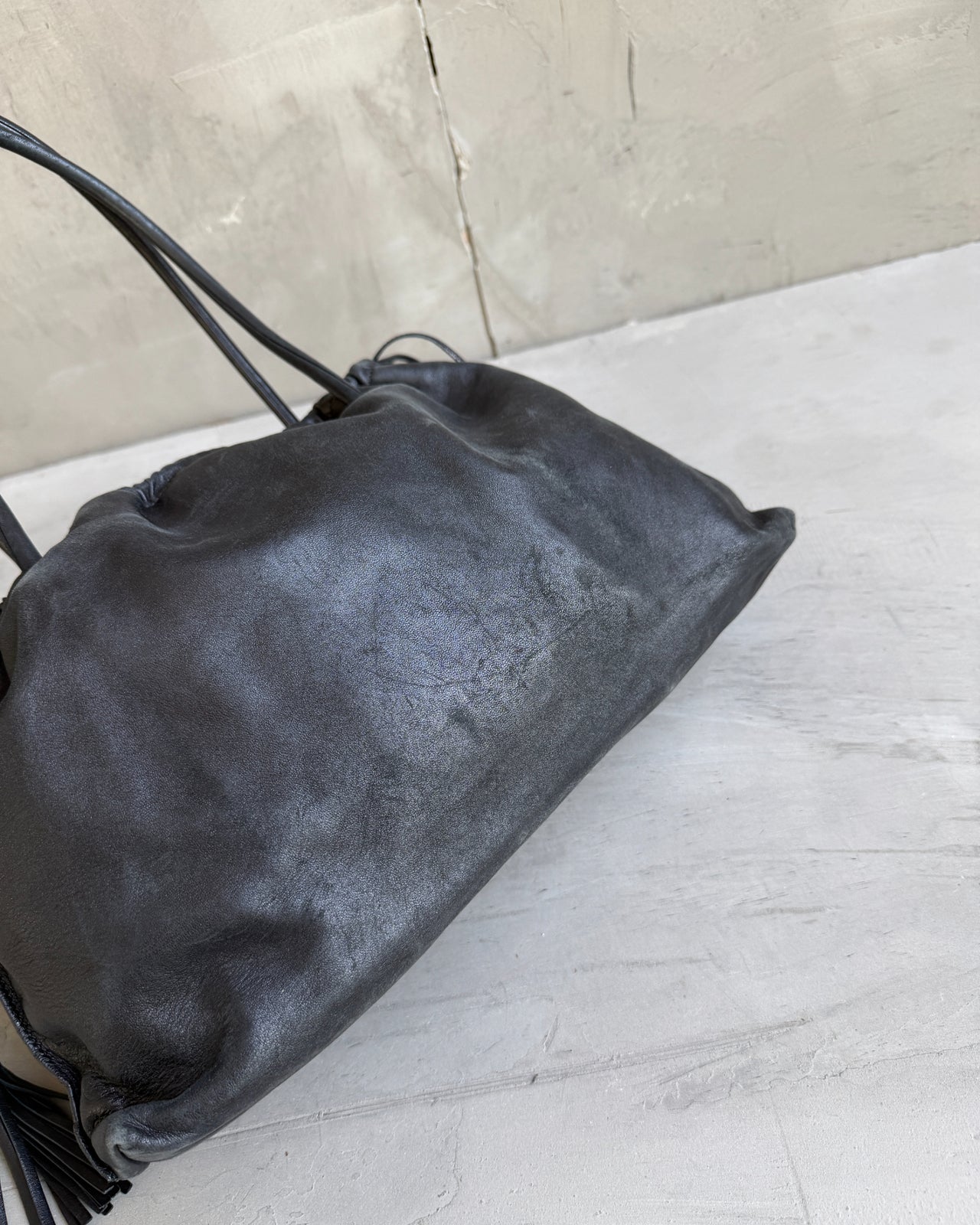 Gucci Black Leather Bag-on a concrete background