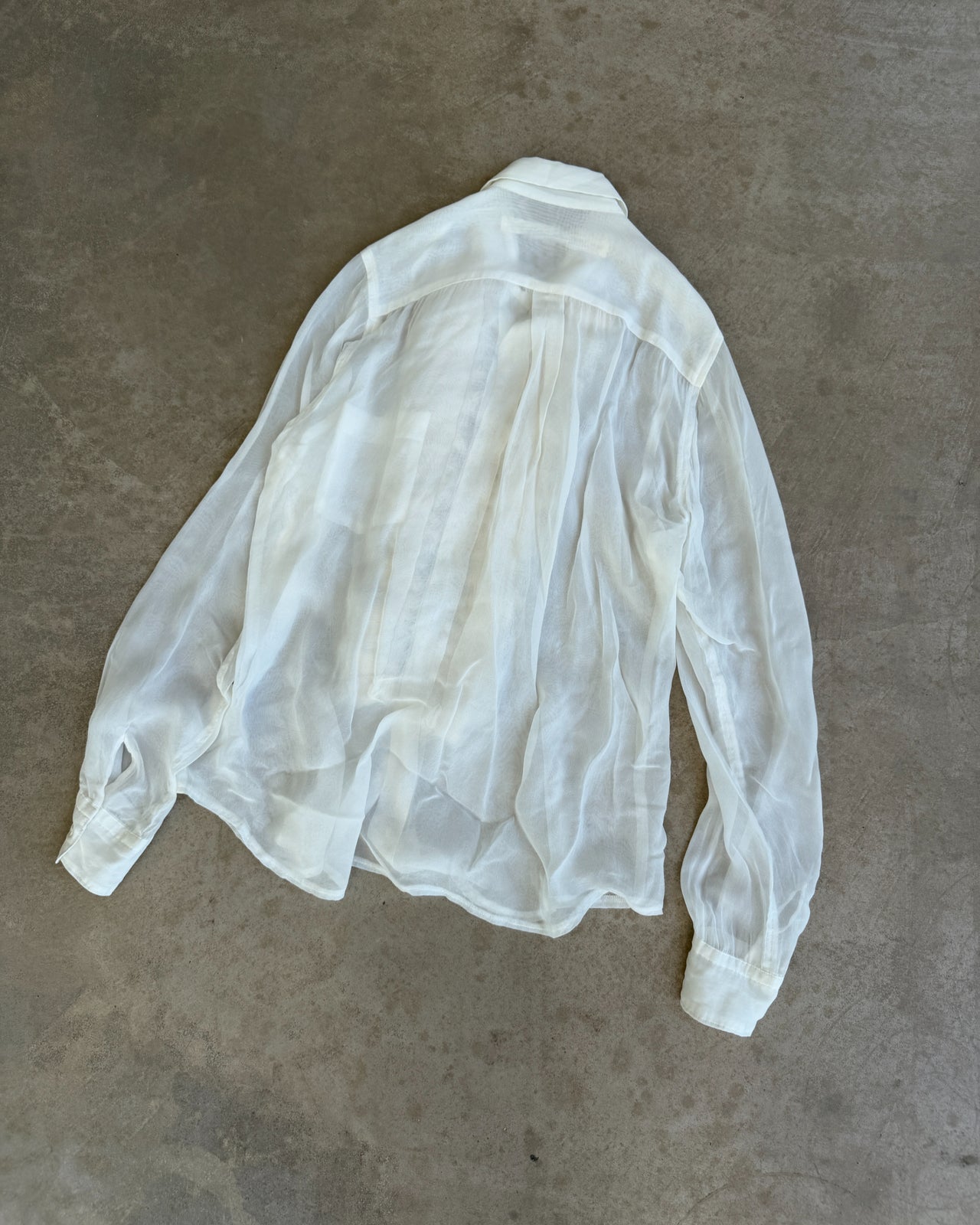 Comme des Garçons Sheer White Shirt-on a concrete background
