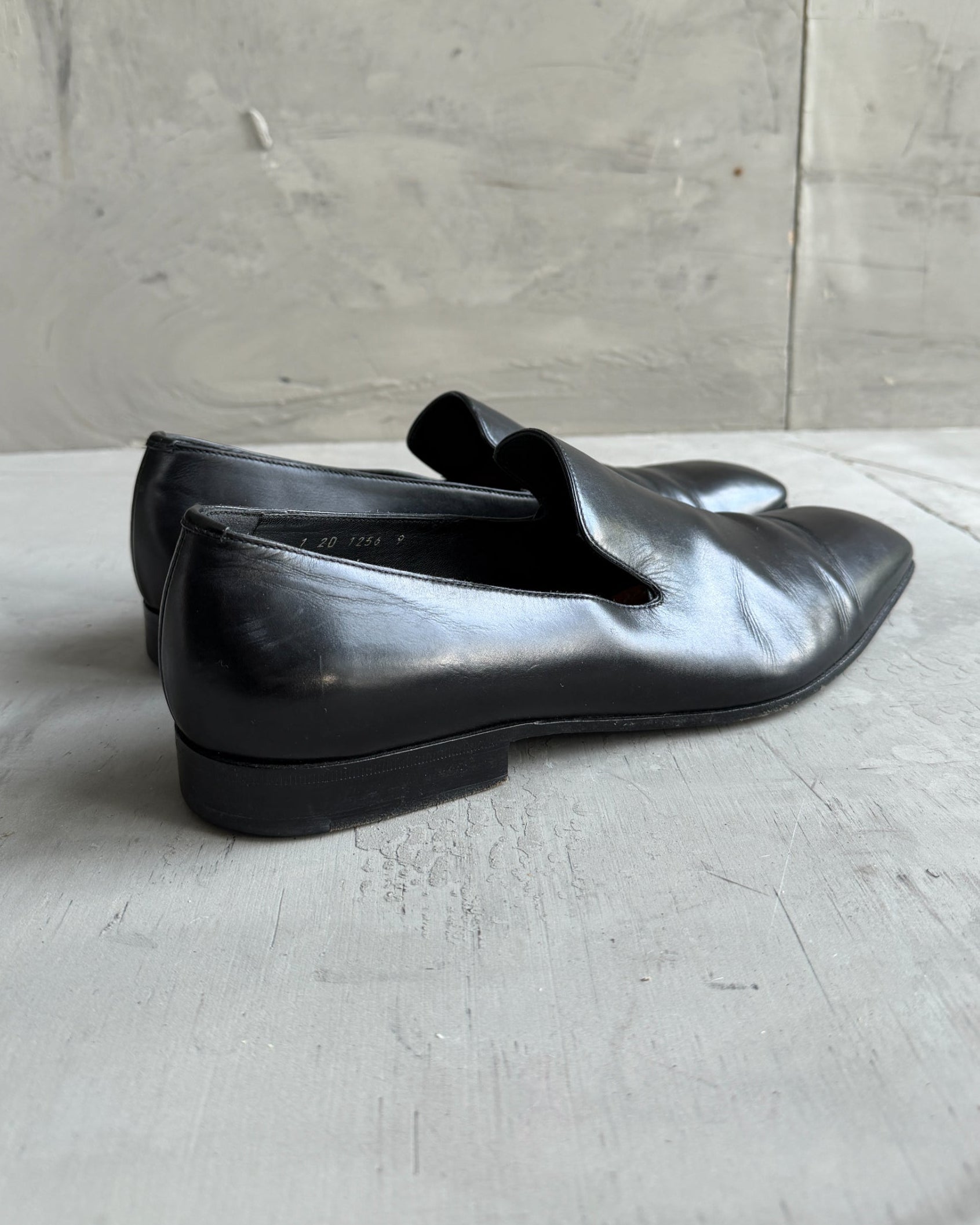 Prada Black Leather Loafers – UK 9-on a concrete background