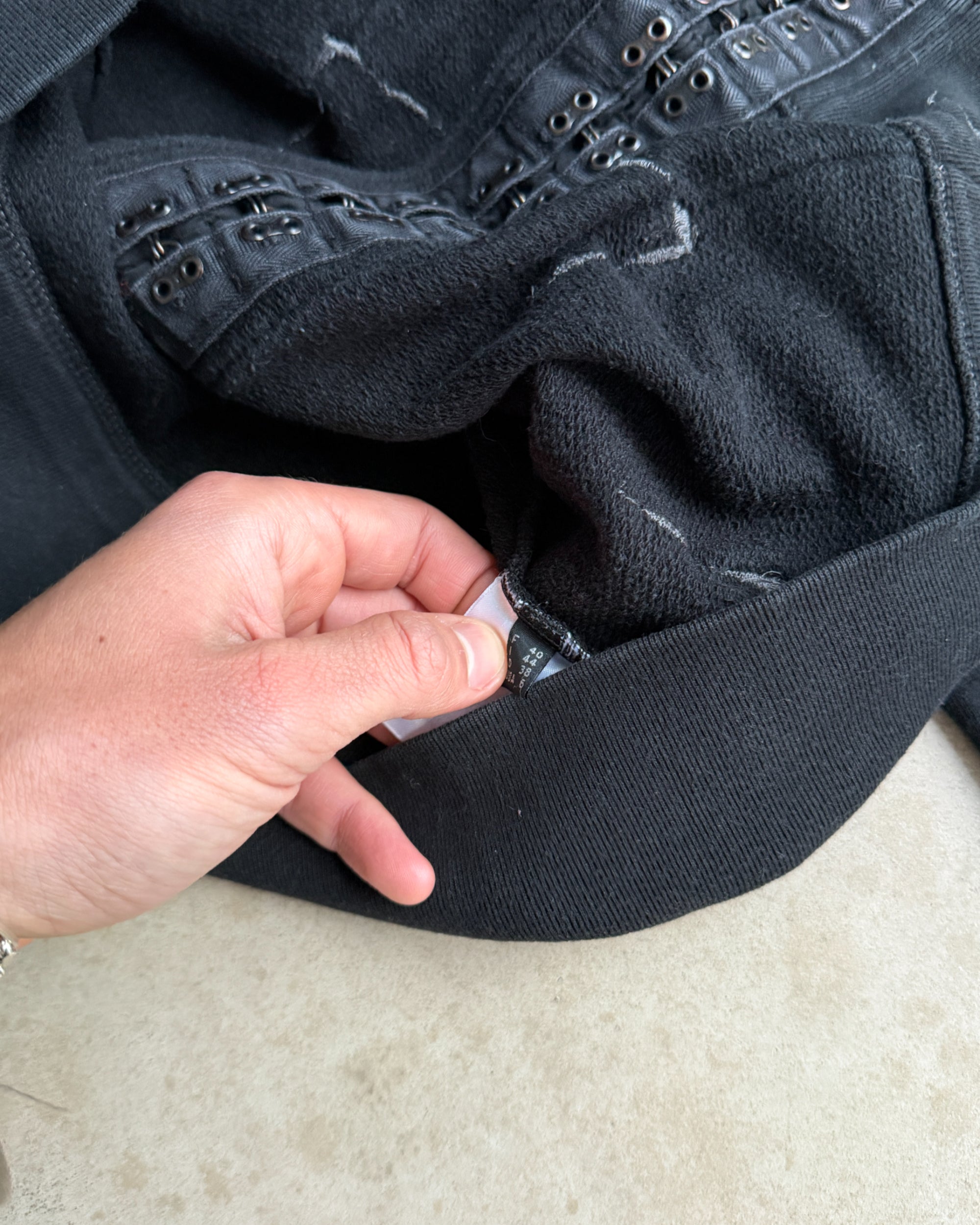 Marithé + François Girbaud Cotton Hoodie – M-on a concrete background