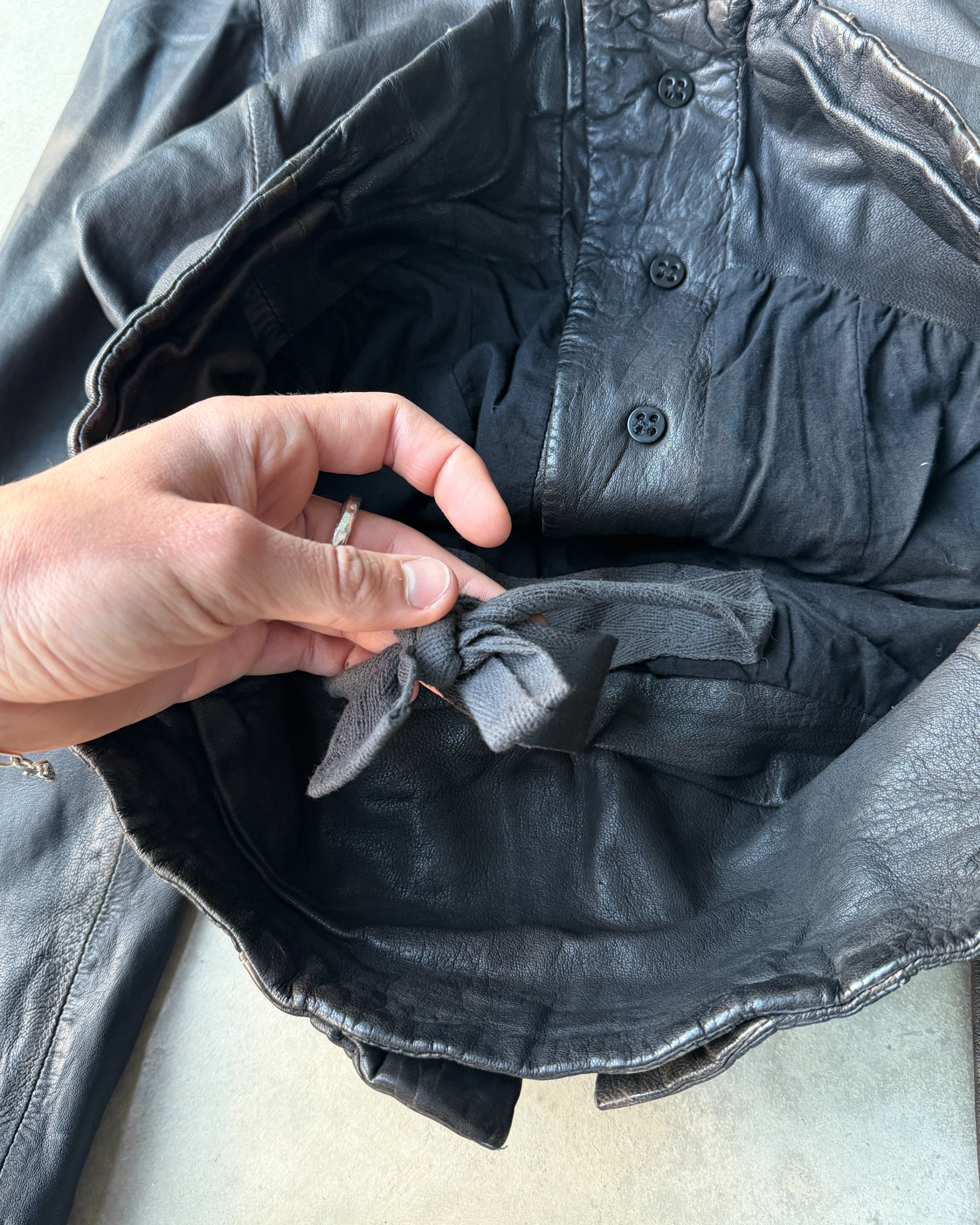 AllSaints 1990s Button-Up Leather Jacket – M-on a concrete background
