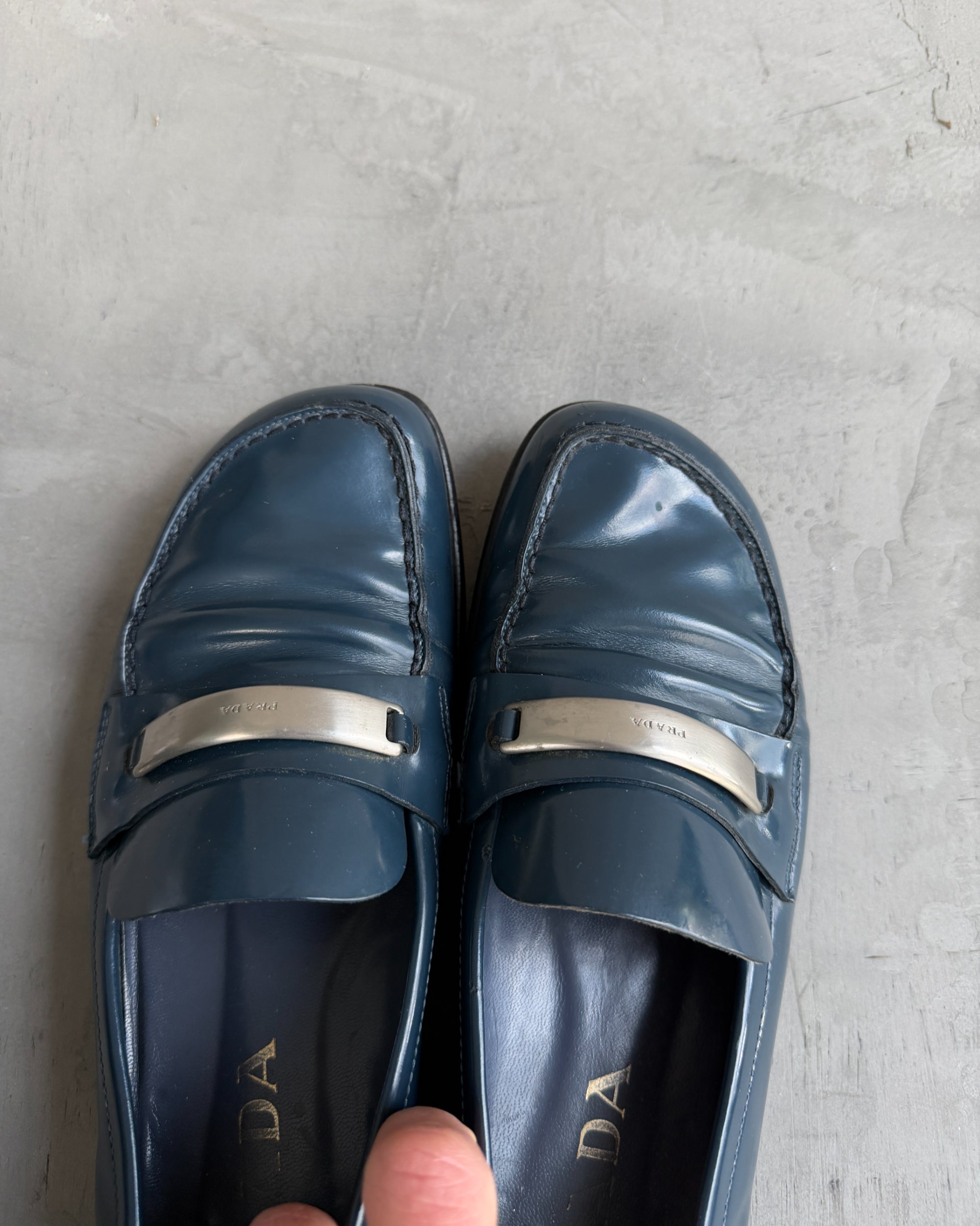 Prada Blue Leather Loafers with Silver Tab – EU 38-on a concrete background