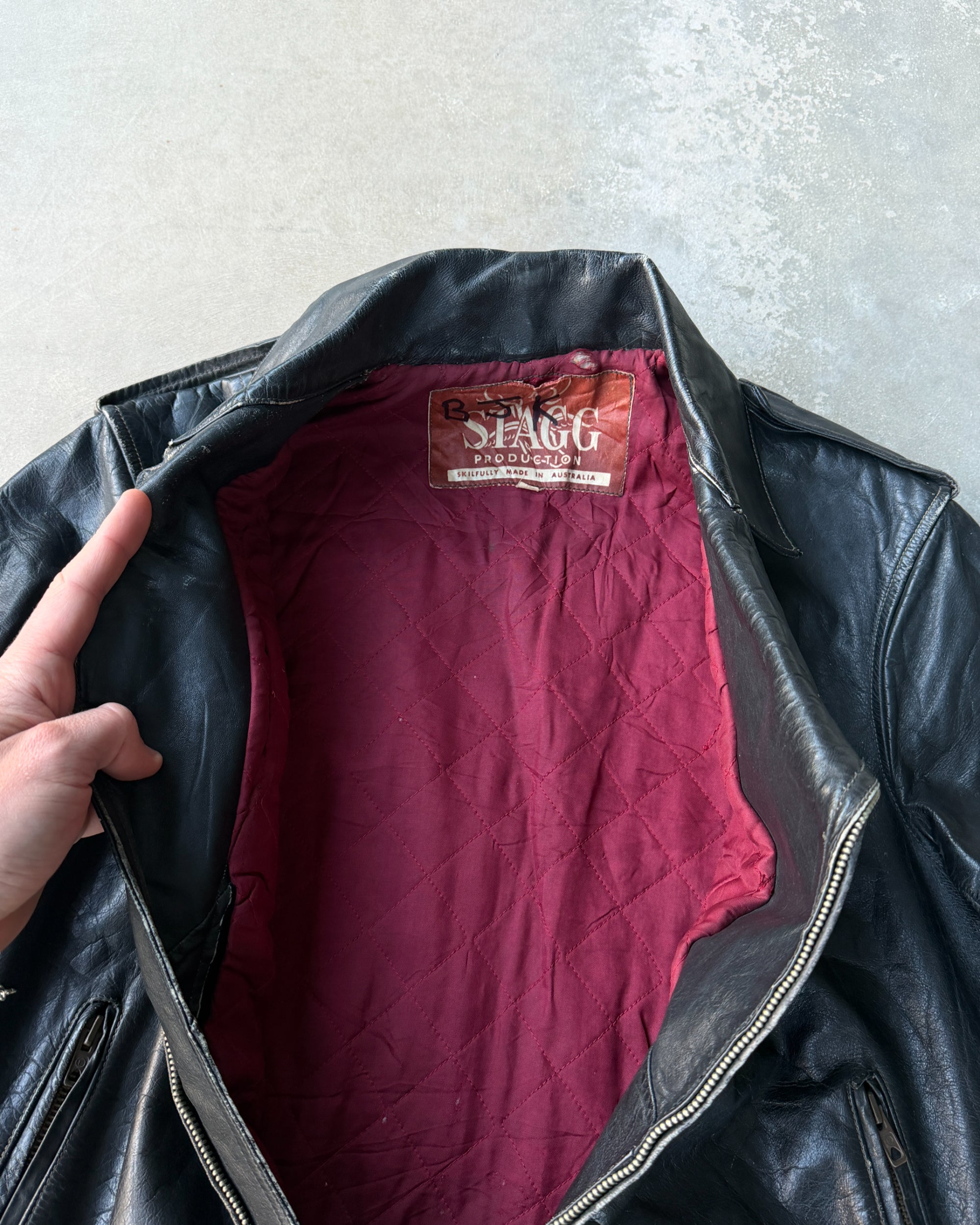 1960s Staggs Leather Moto Jacket – S-on a concrete background