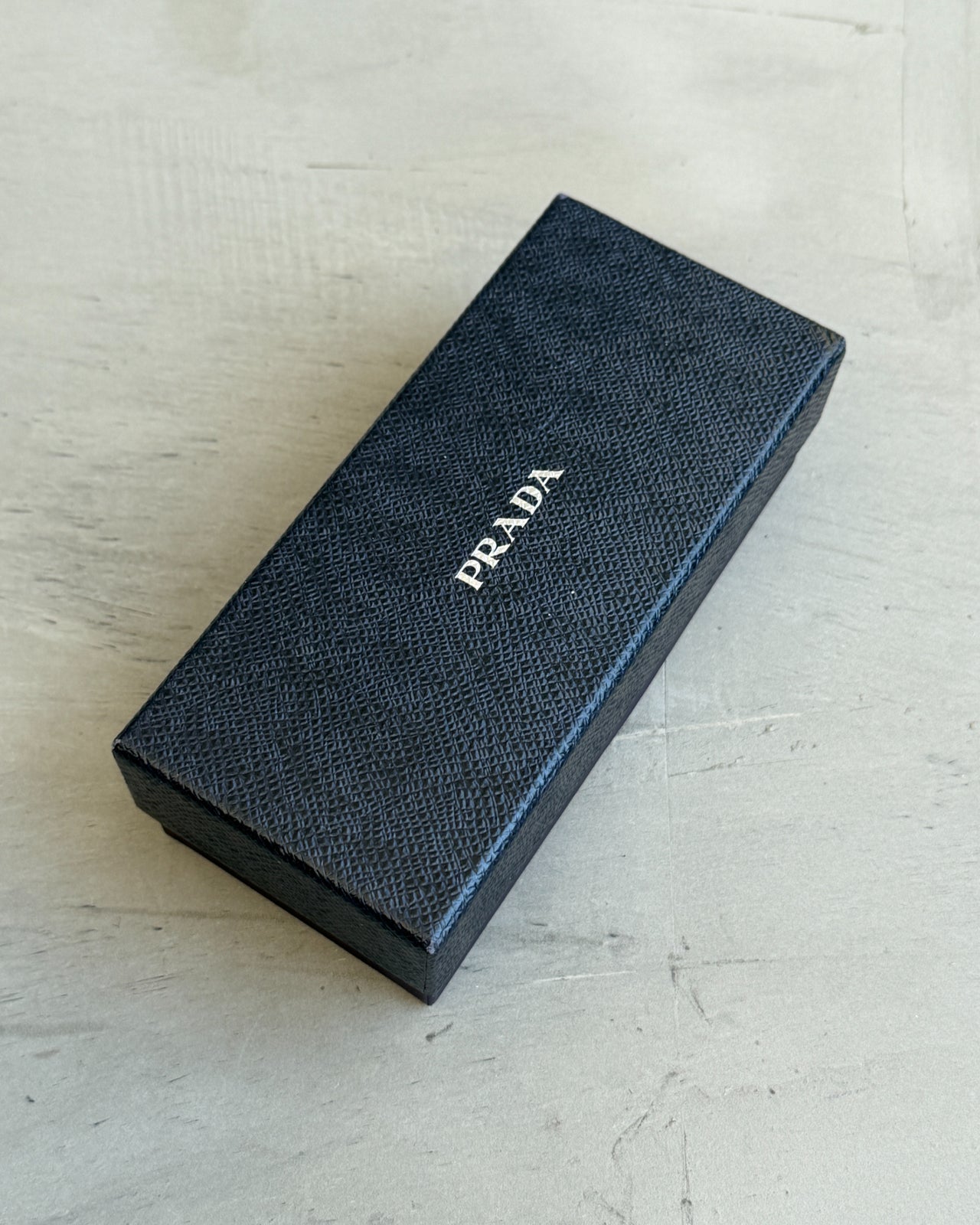 Prada Clear Lens Half Rim Glasses-on a concrete background