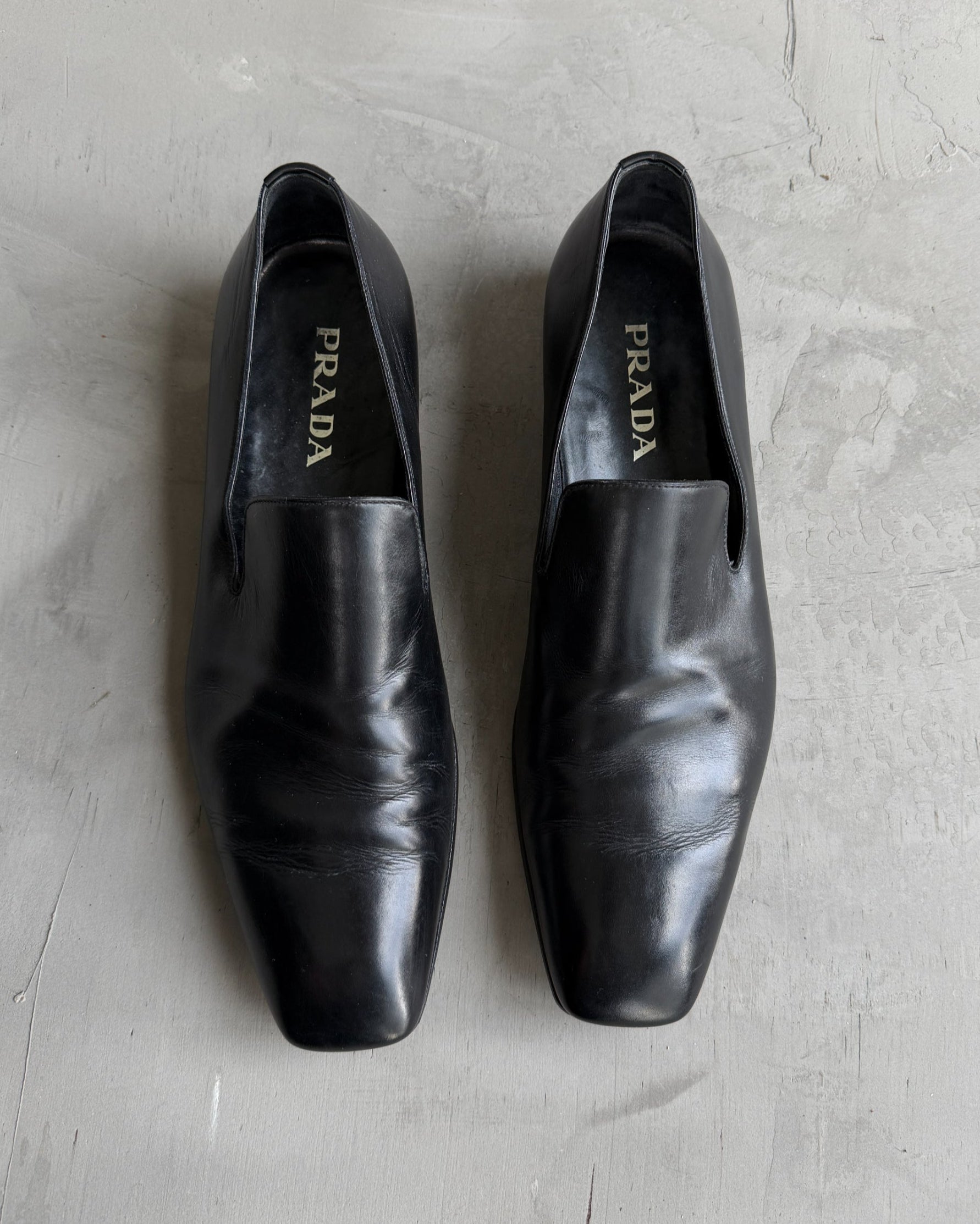 Prada Black Leather Loafers – UK 9-on a concrete background