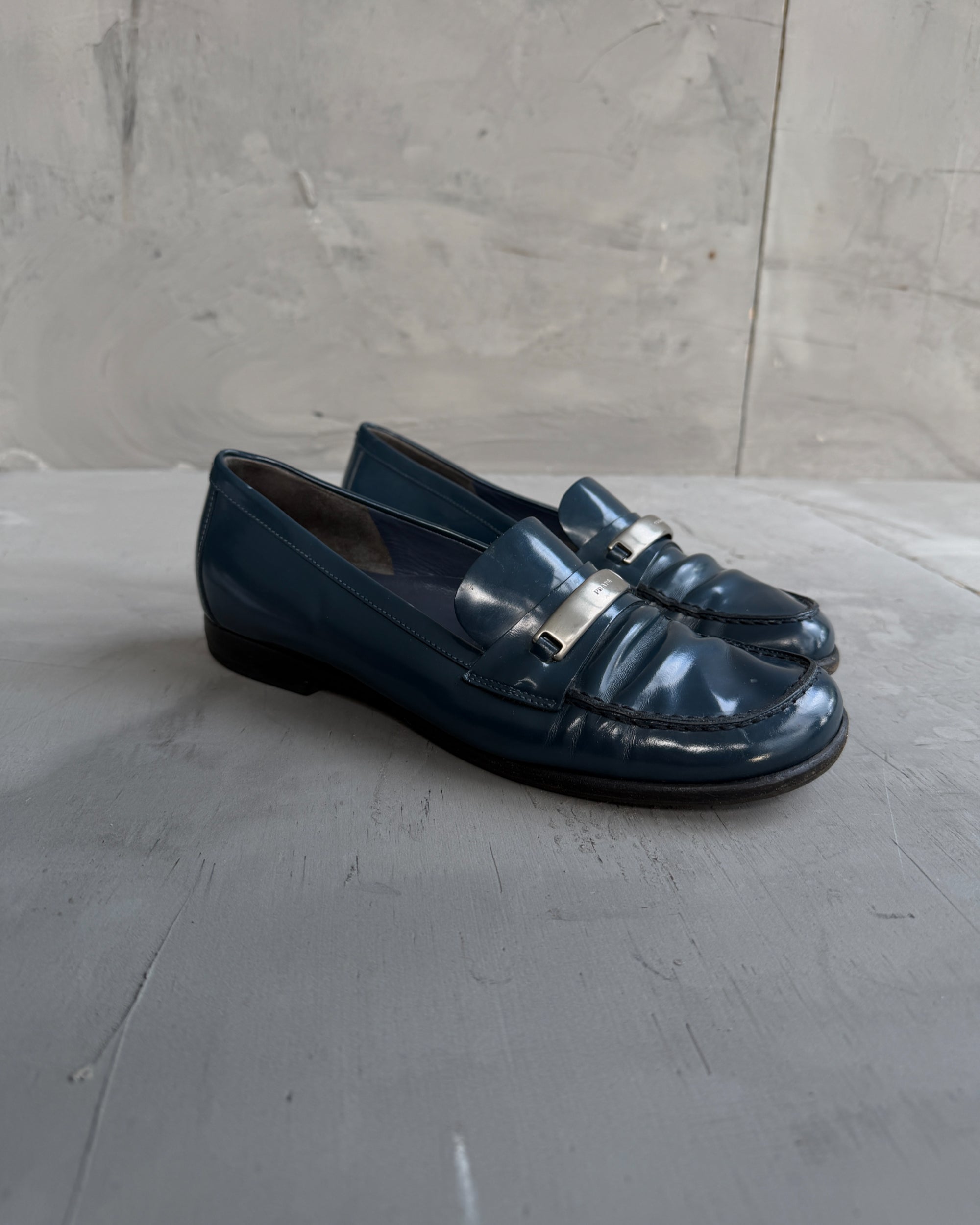 Prada Blue Leather Loafers with Silver Tab – EU 38-on a concrete background