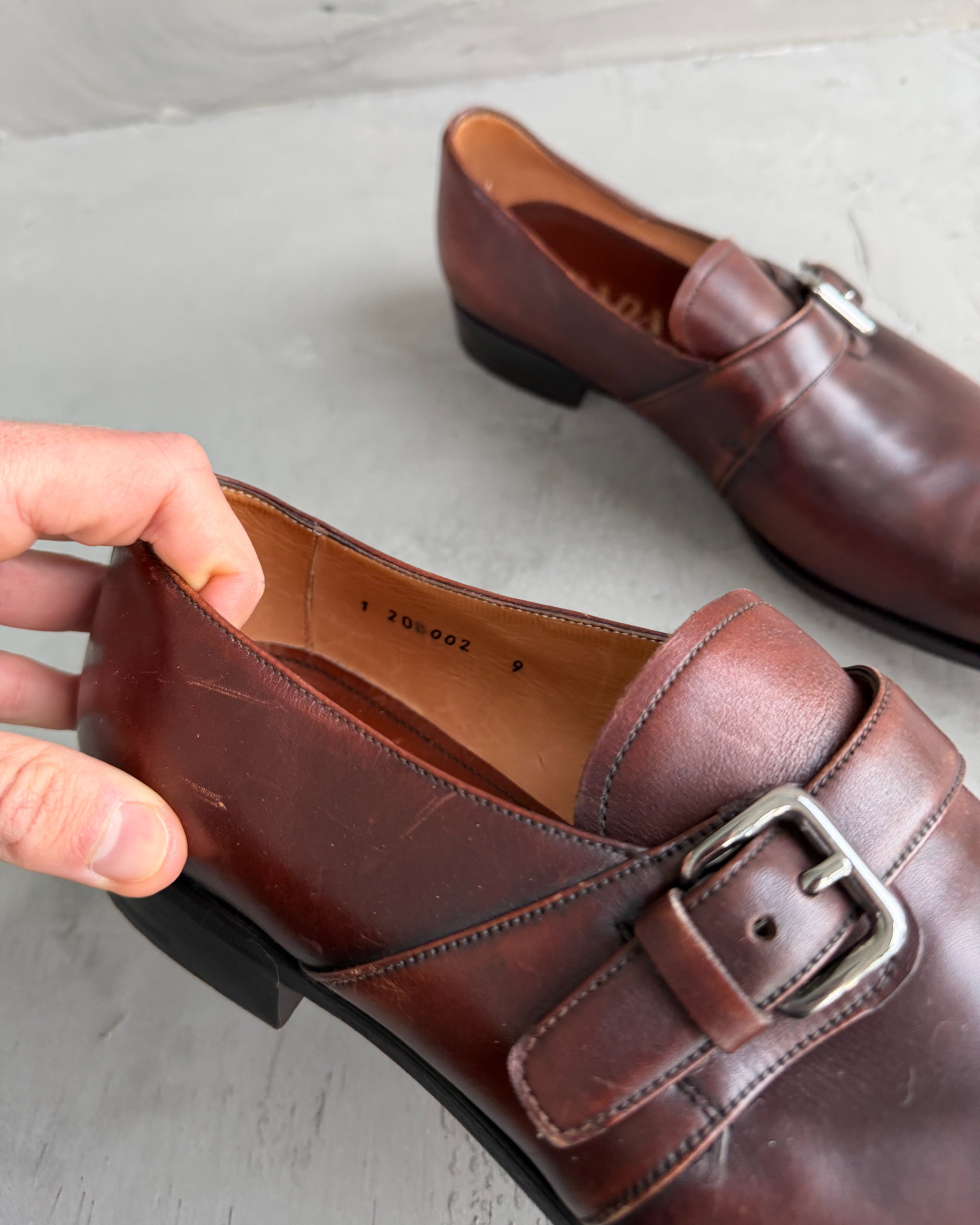 Prada Buckle Leather Derbys – UK 9-on a concrete background