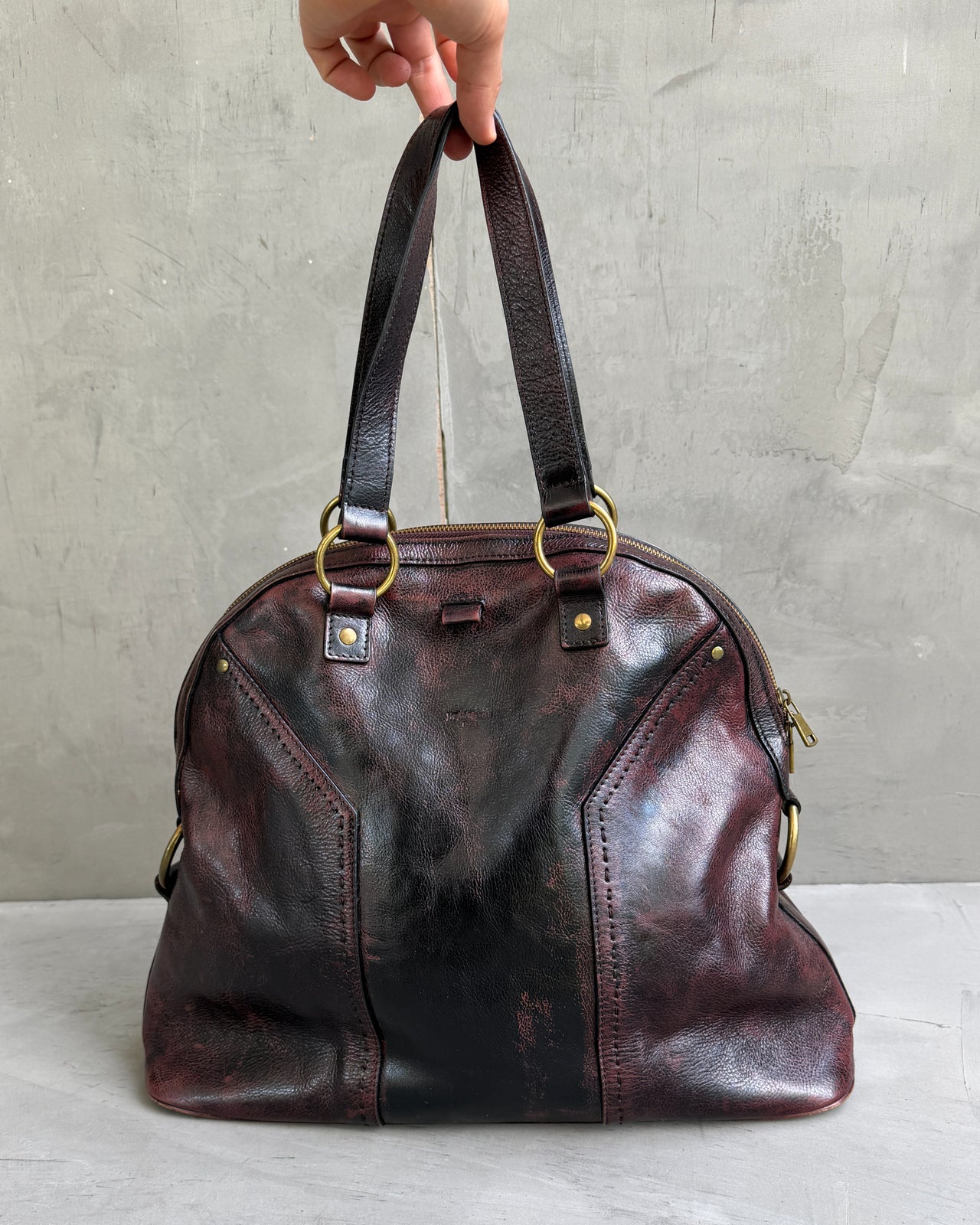 Yves Saint Laurent Leather Muse Bag-on a concrete background