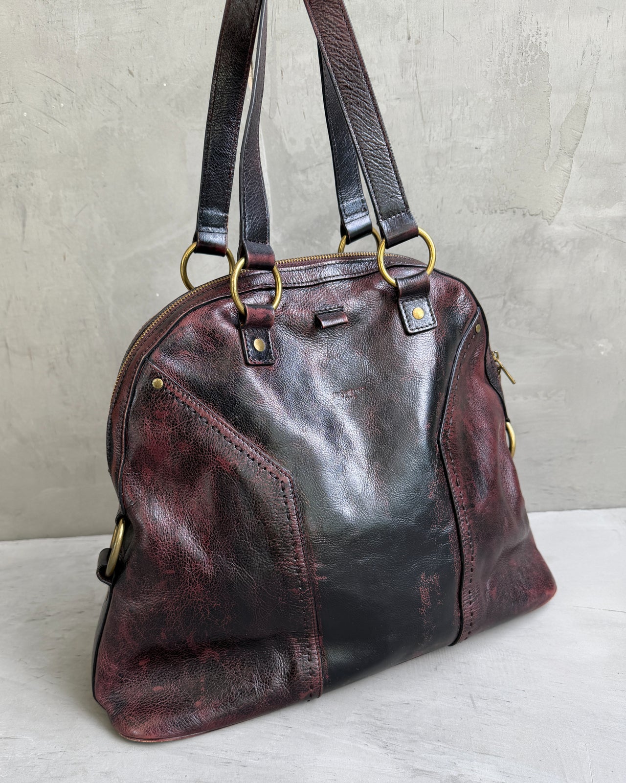 Yves Saint Laurent Leather Muse Bag-on a concrete background