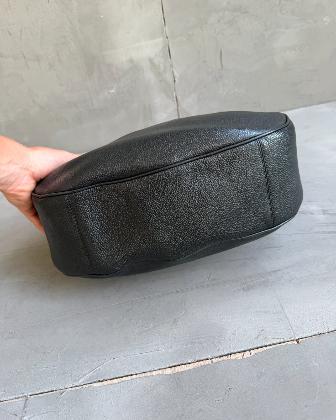 Coach Black Leather Shoulder Bag with Crossbody Strap-on a concrete background