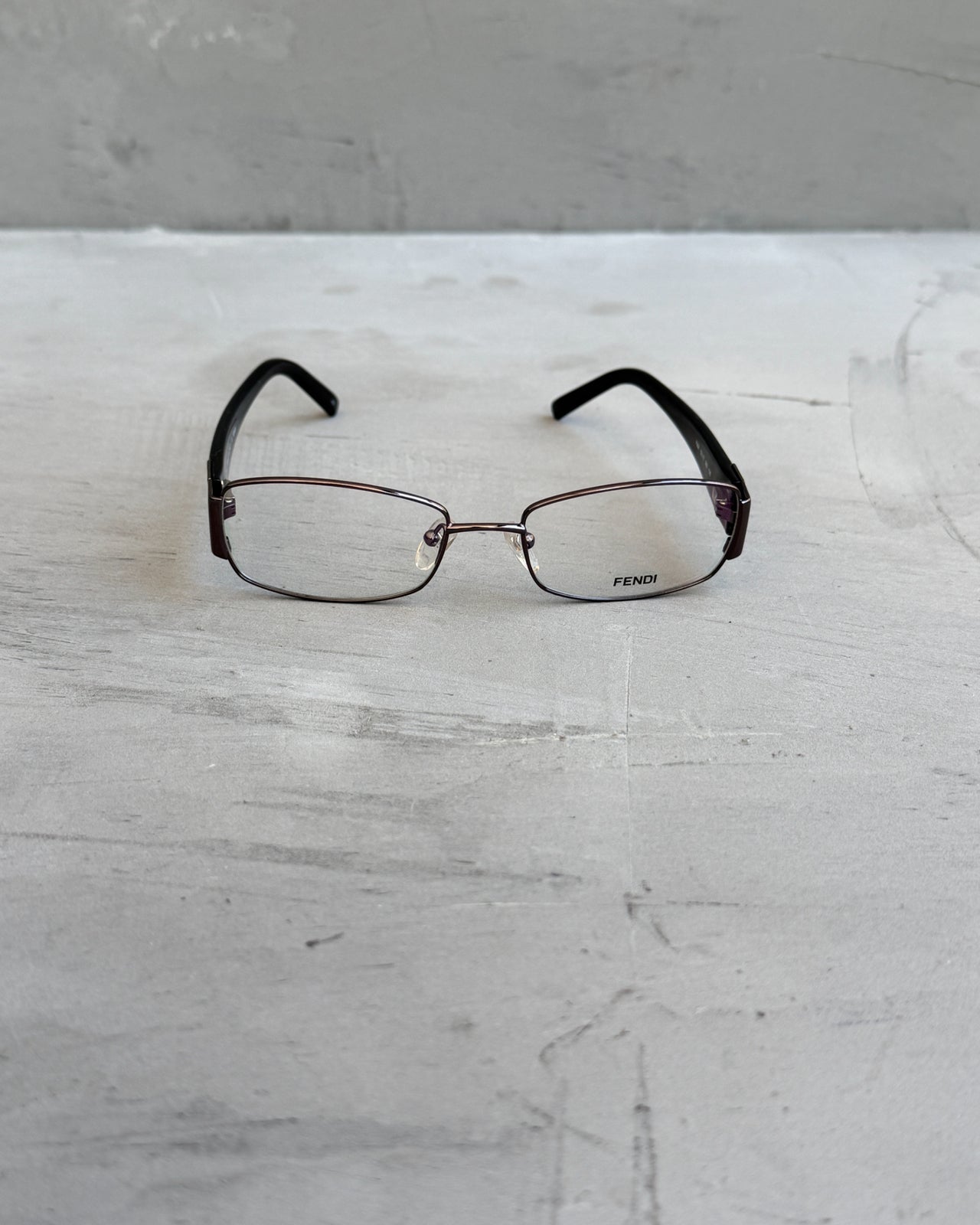 Fendi Clear Lens Silver Frame Glasses-on a concrete background