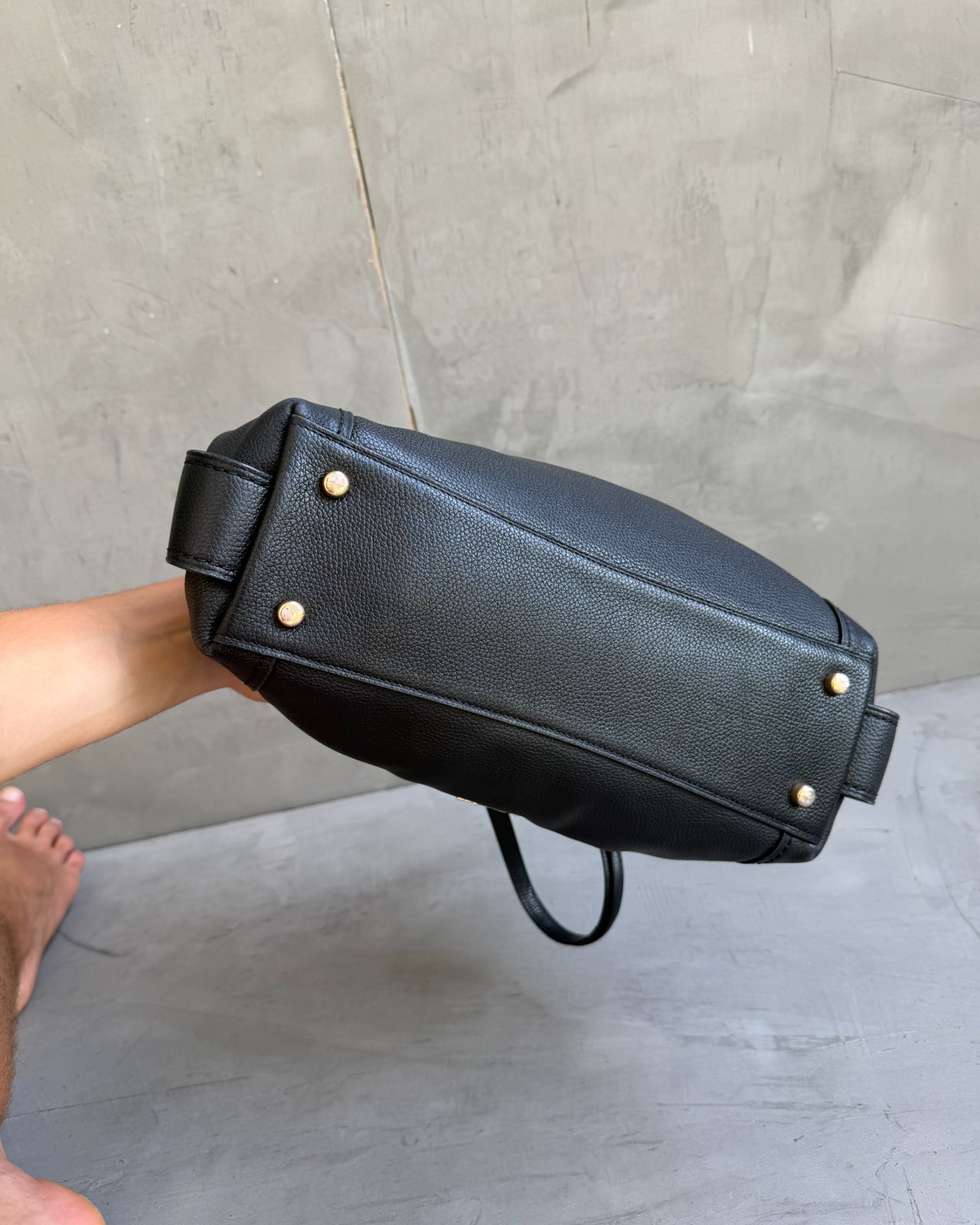 Coach Black Leather Bag-on a concrete background