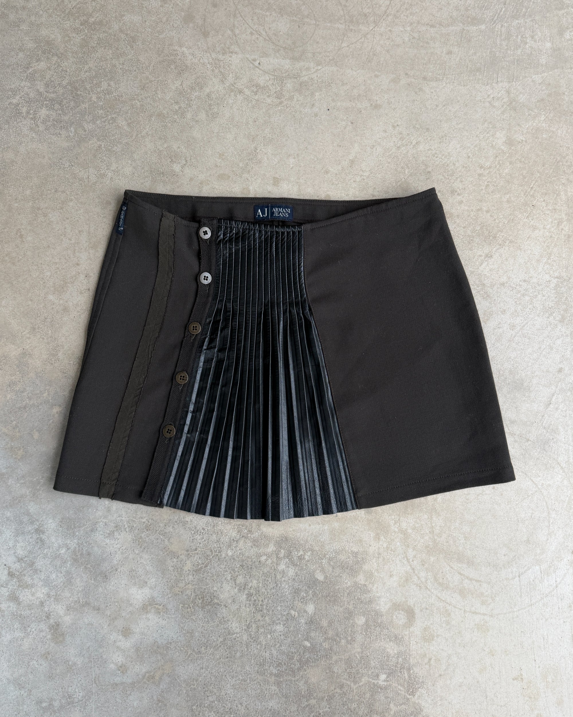 Armani Jeans Pleated Mini Skirt with Leather Panel – S-on a concrete background