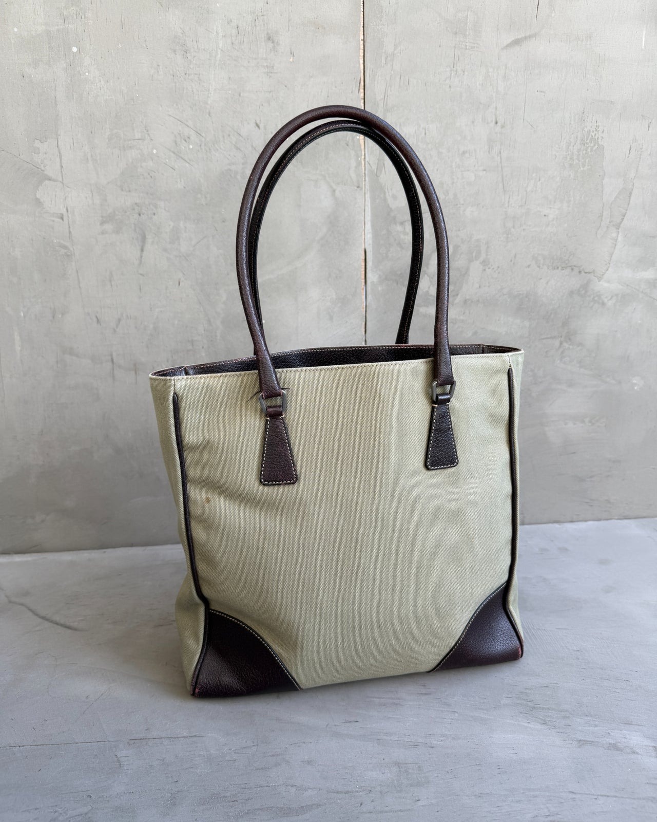 Prada Canvas and Leather Tote Bag-on a concrete background