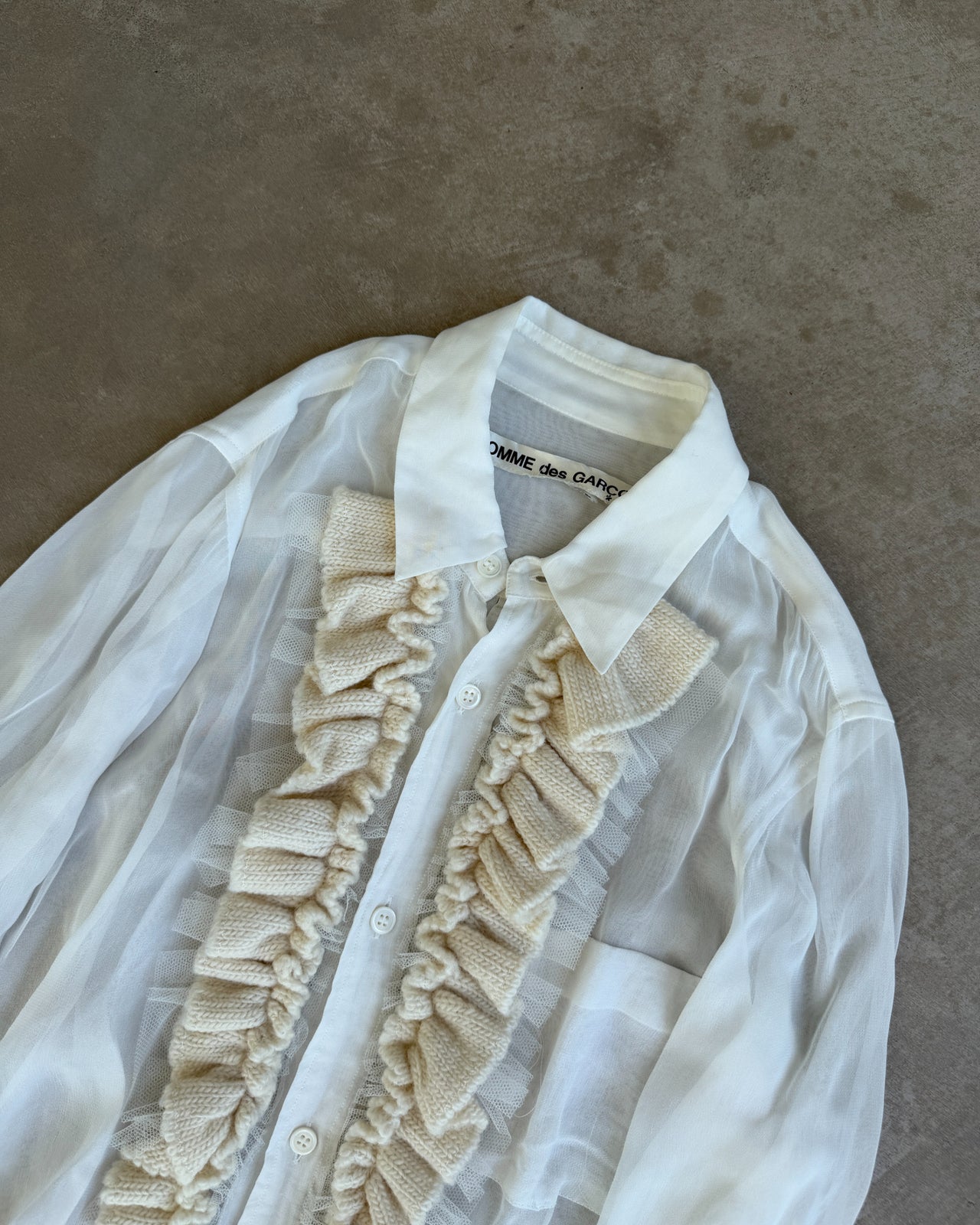 Comme des Garçons Sheer White Shirt-on a concrete background