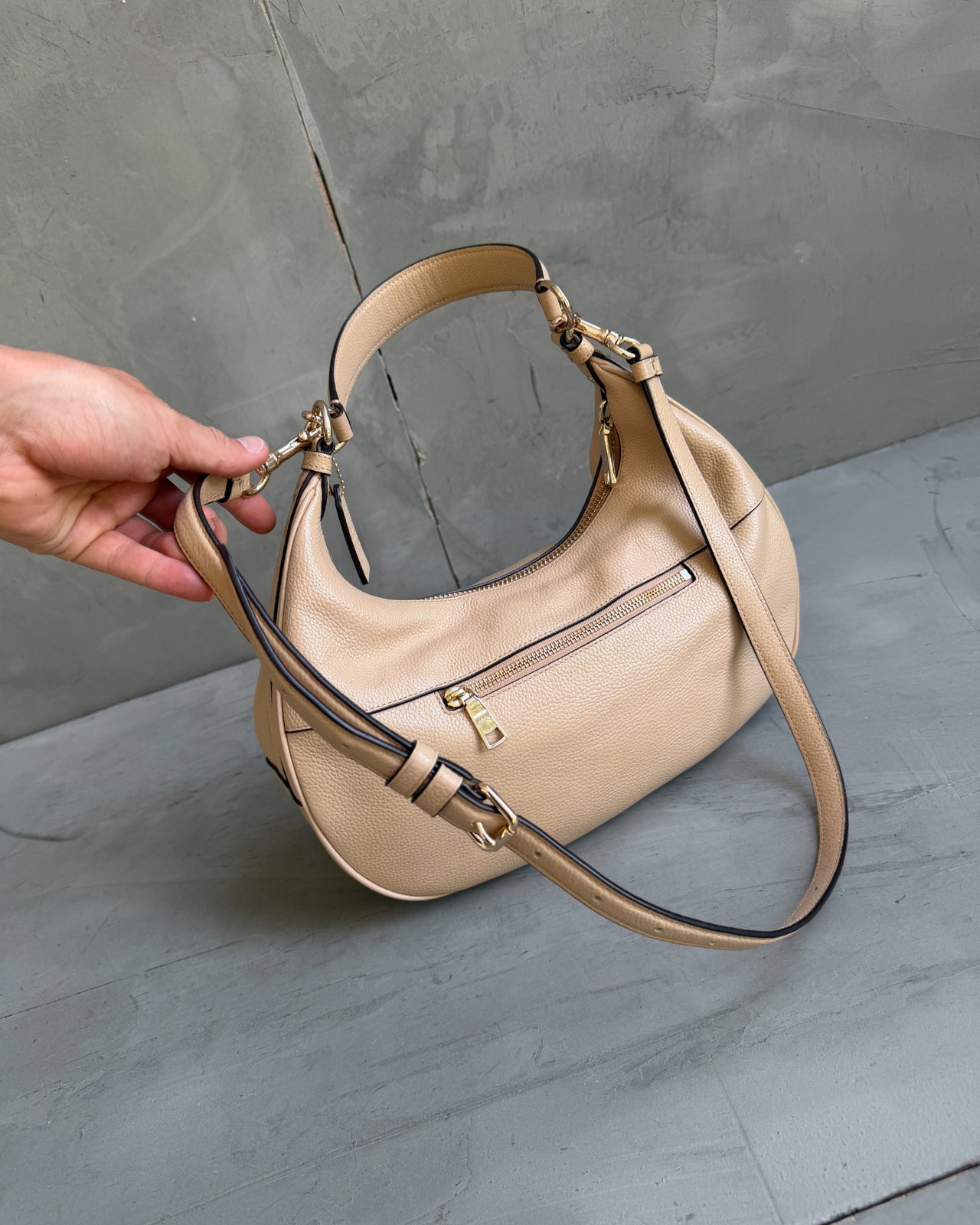 Coach Beige Leather Handbag-on a concrete background