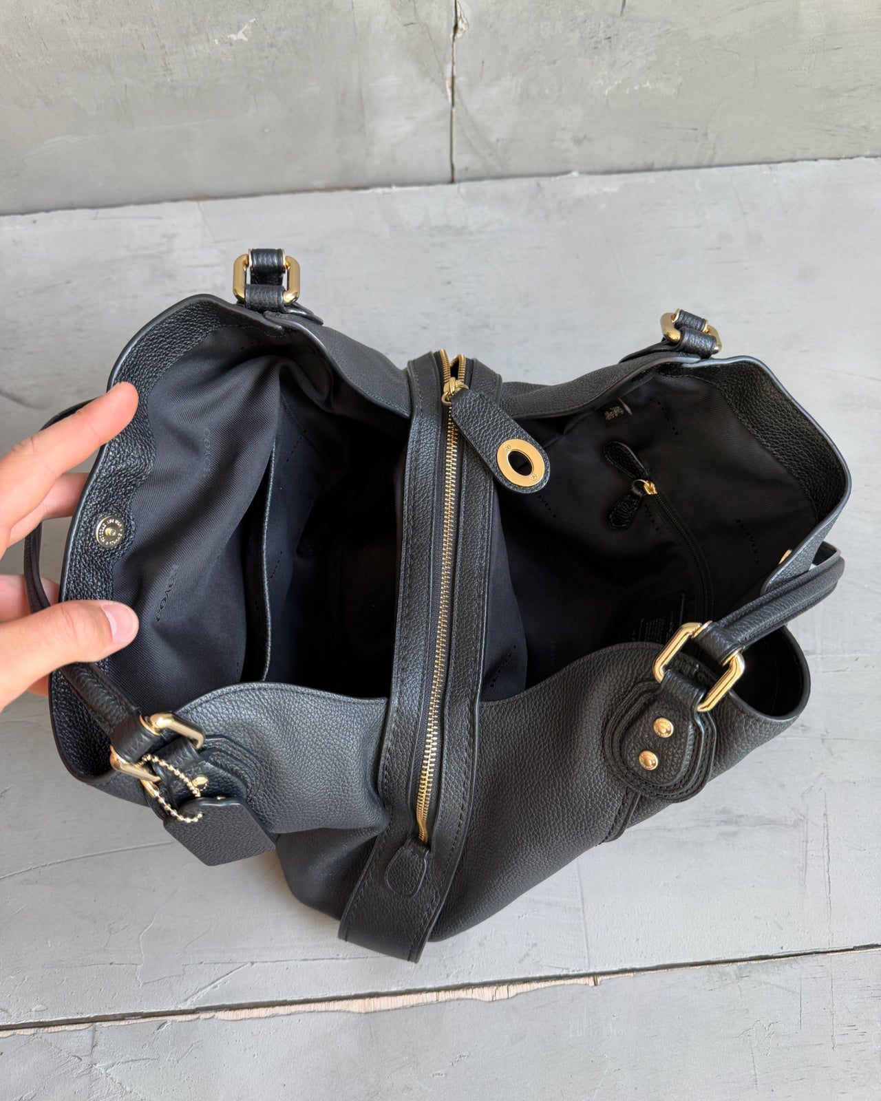 Coach Black Leather Bag-on a concrete background