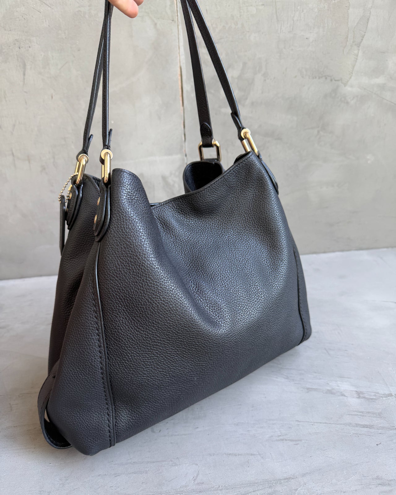 Coach Black Leather Bag-on a concrete background