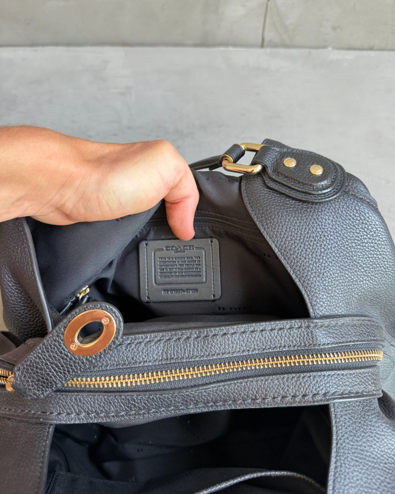 Coach Black Leather Bag-on a concrete background