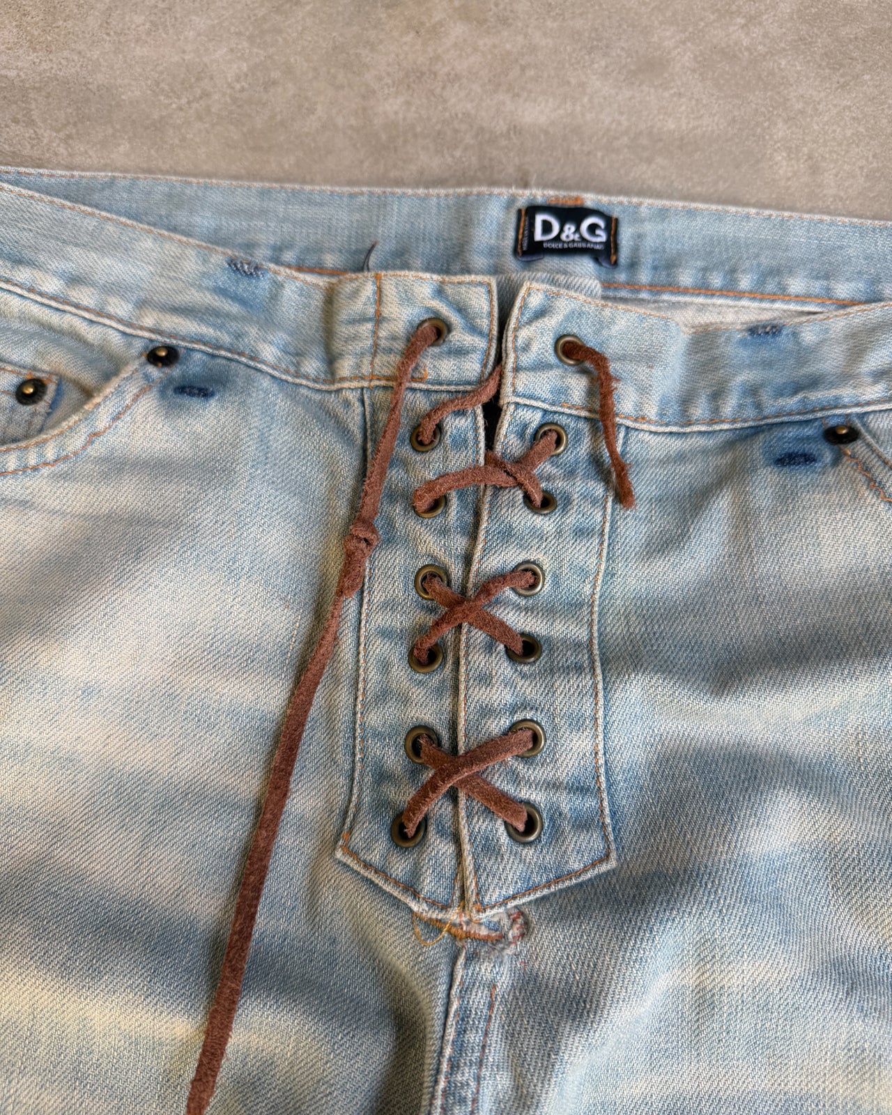 Dolce & Gabbana Light Blue Distressed Wide Leg Jeans with Leather Lace Up Fly – M-on a concrete background