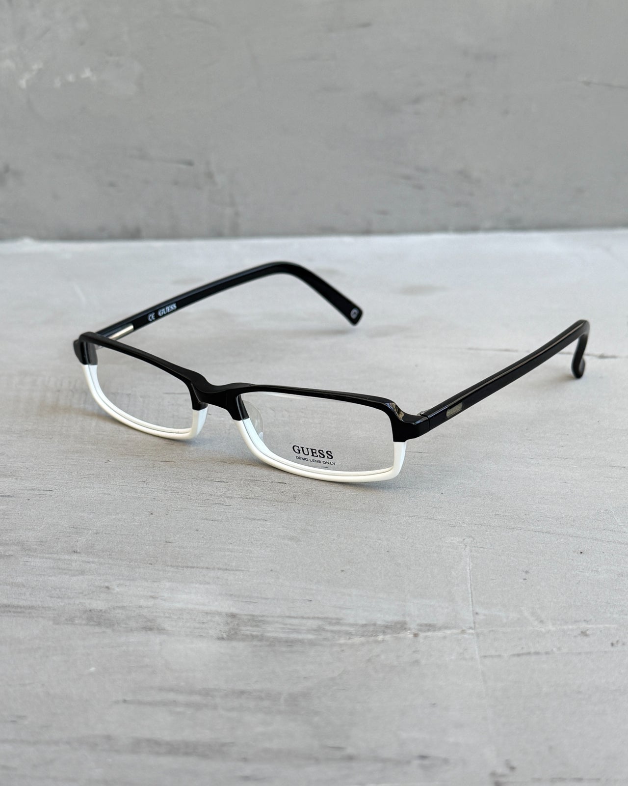 Guess Two Tone Black and White Clear Lens Glasses-on a concrete background