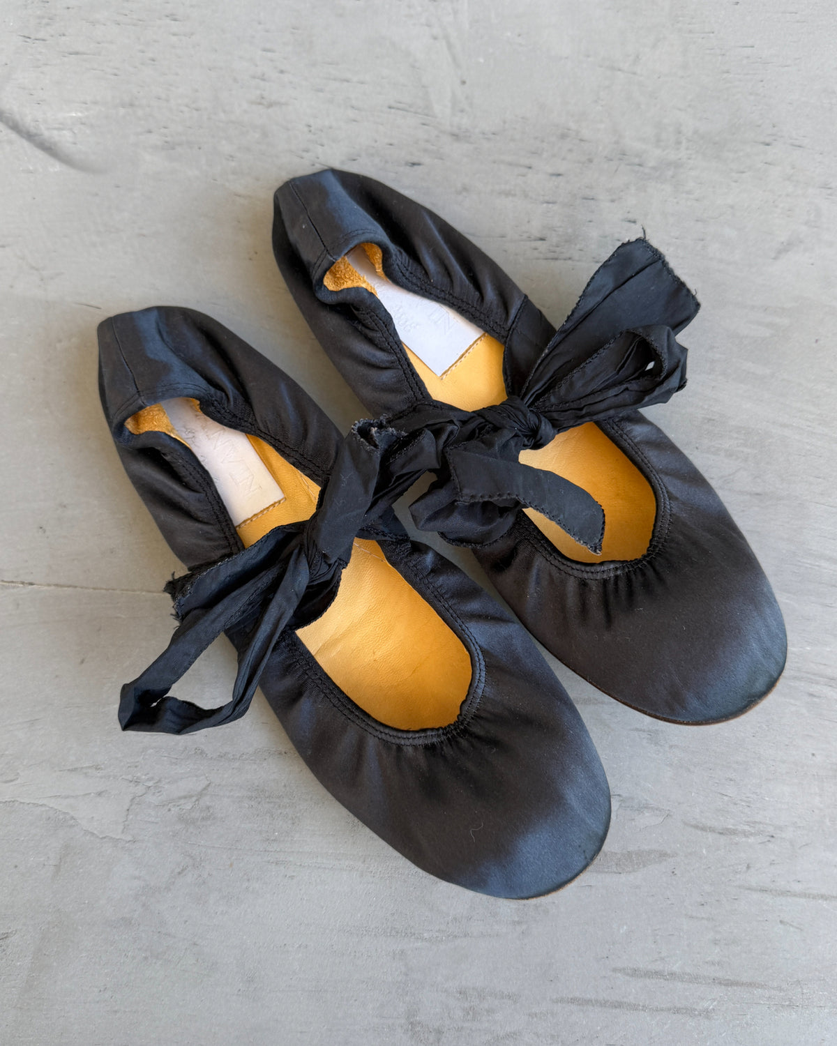 Lanvin Silk Ballet Flat with Ankle Tie-on a concrete background