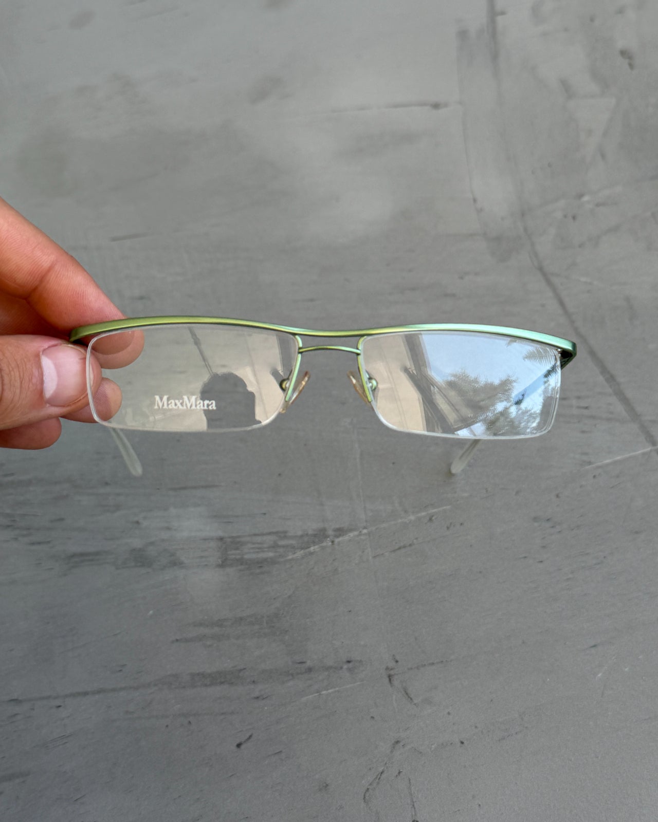 Max Mara Clear Lens Rimless Glasses-on a concrete background