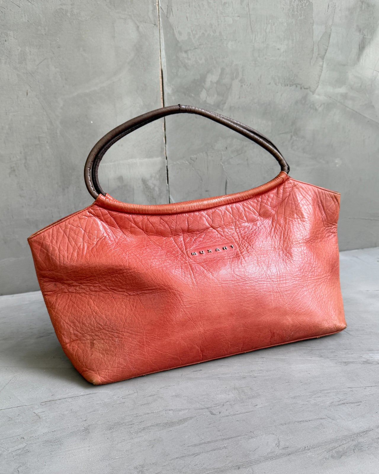 Muxart Leather Handbag-on a concrete background