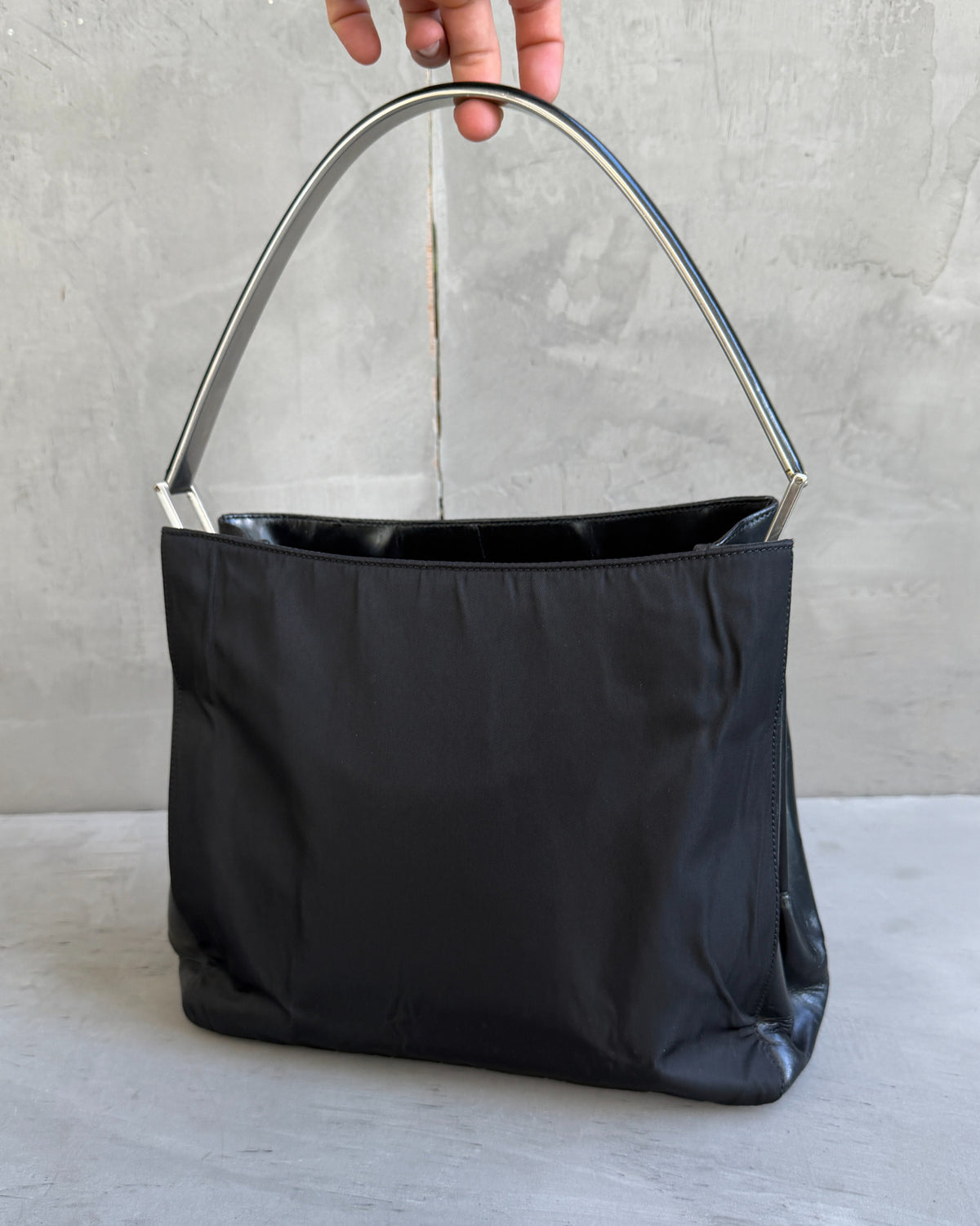 Prada Black Nylon and Leather Shoulder Bag-on a concrete background