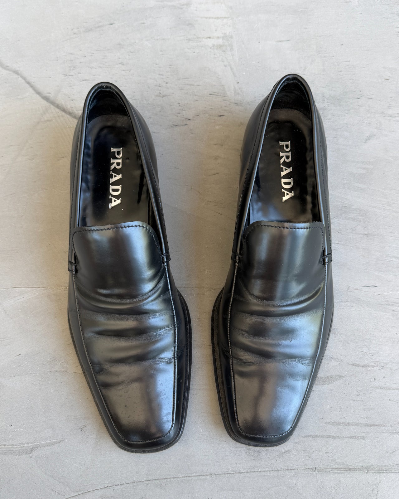 Prada Black Leather Loafers – UK 8.5-on a concrete background