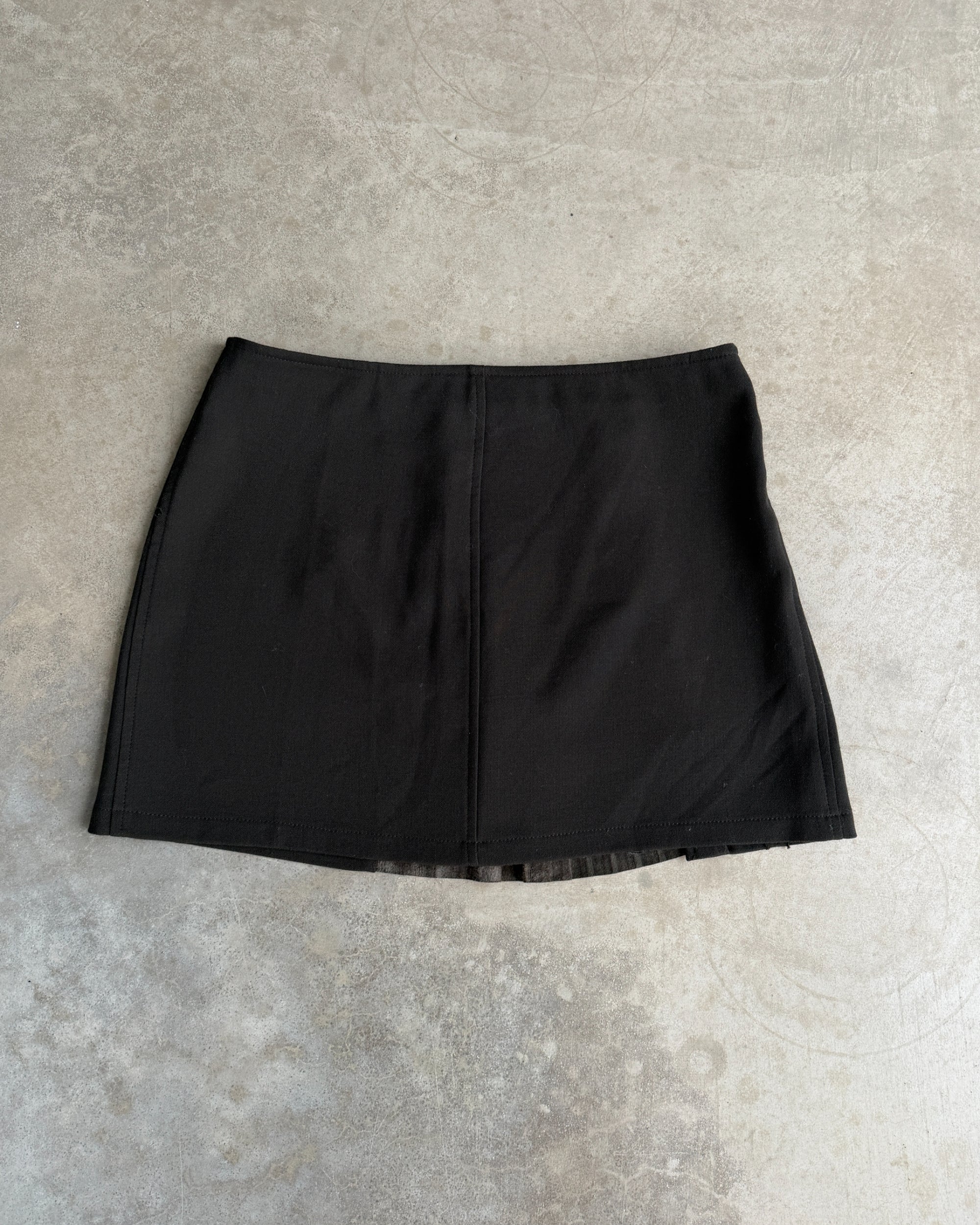 Armani Jeans Pleated Mini Skirt with Leather Panel – S-on a concrete background