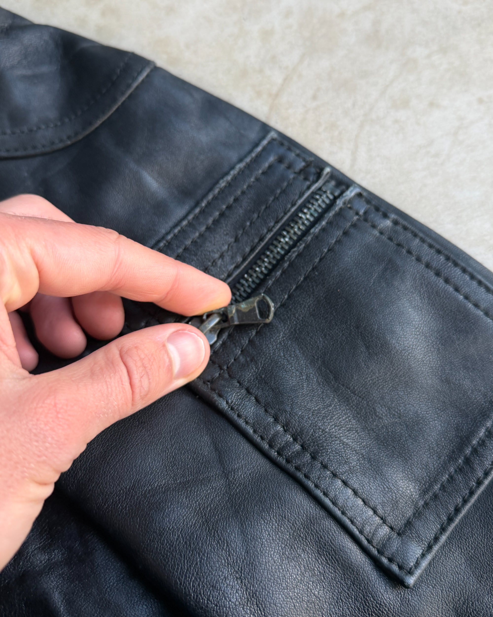 Italian Black Leather Multi-Pocket Jacket – S-on a concrete background