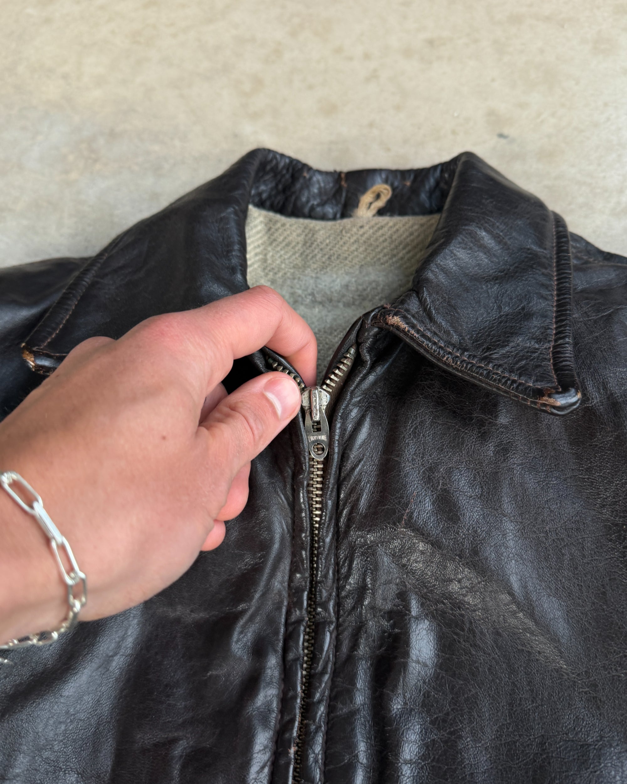 1970s Vintage Leather Jacket with Wool Lining – S-on a concrete background