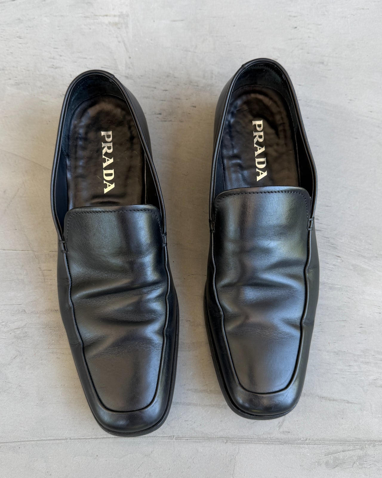 Prada Black Leather Loafers – UK 7-on a concrete background