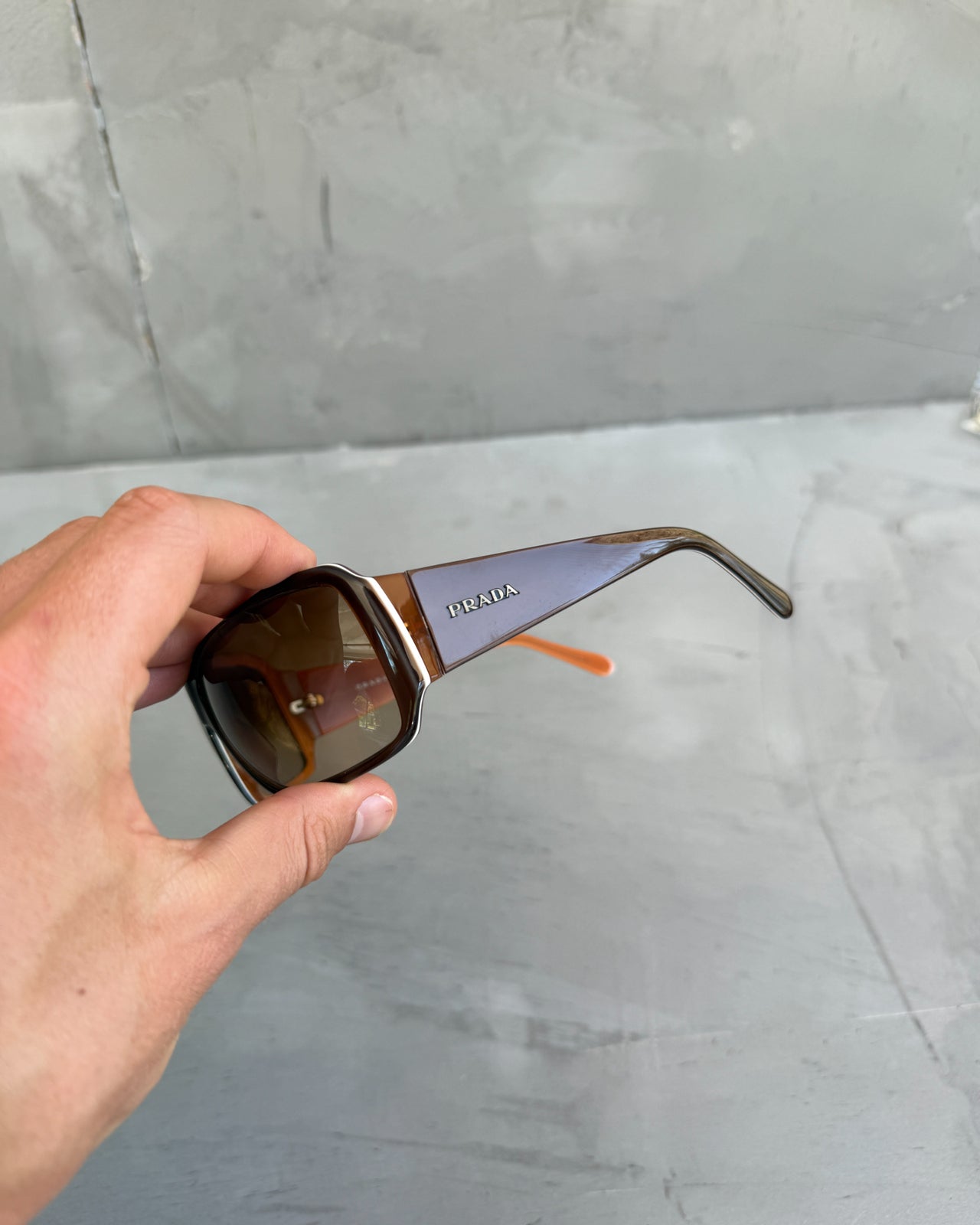Prada Brown Sunglasses-on a concrete background