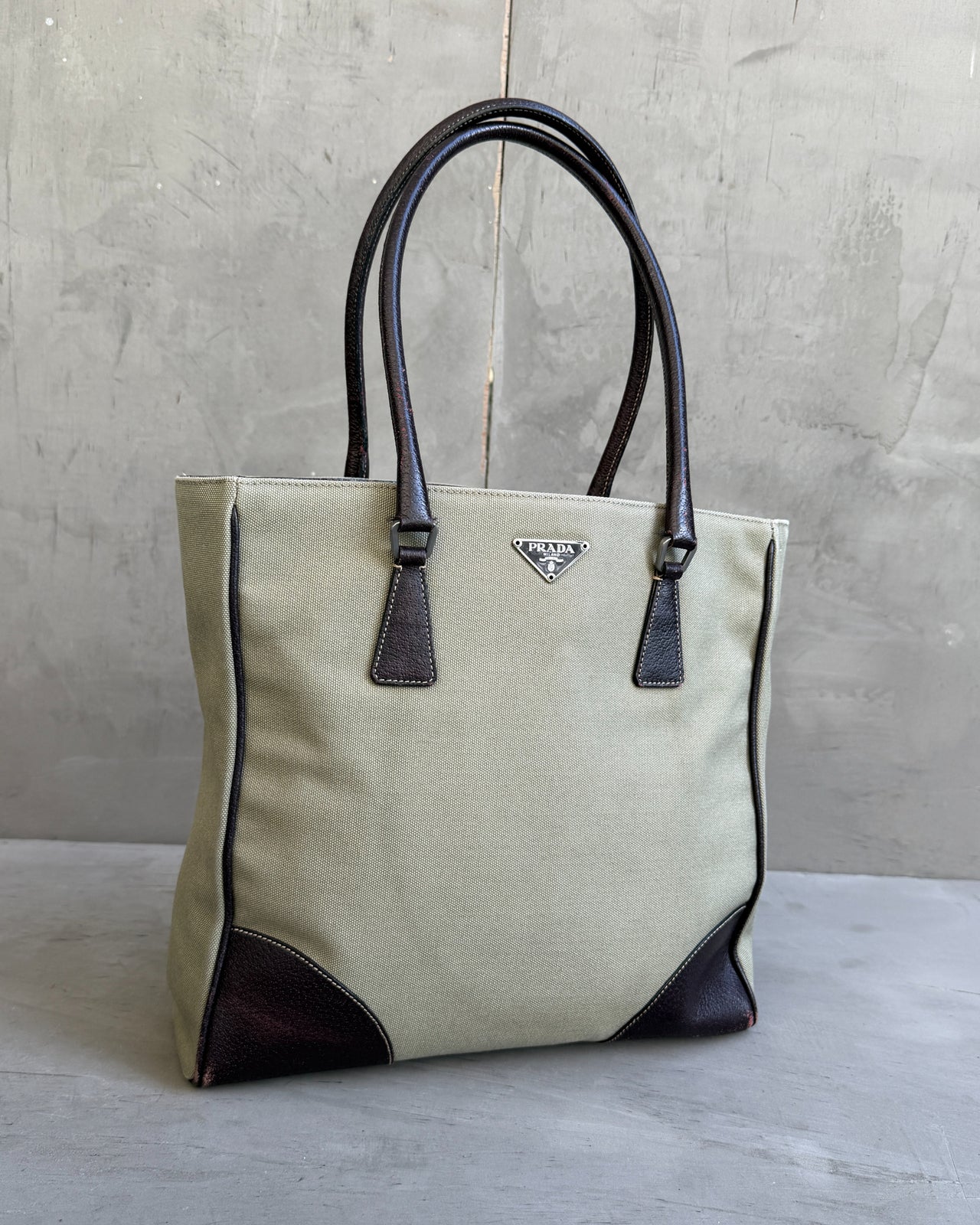 Prada Canvas and Leather Tote Bag-on a concrete background
