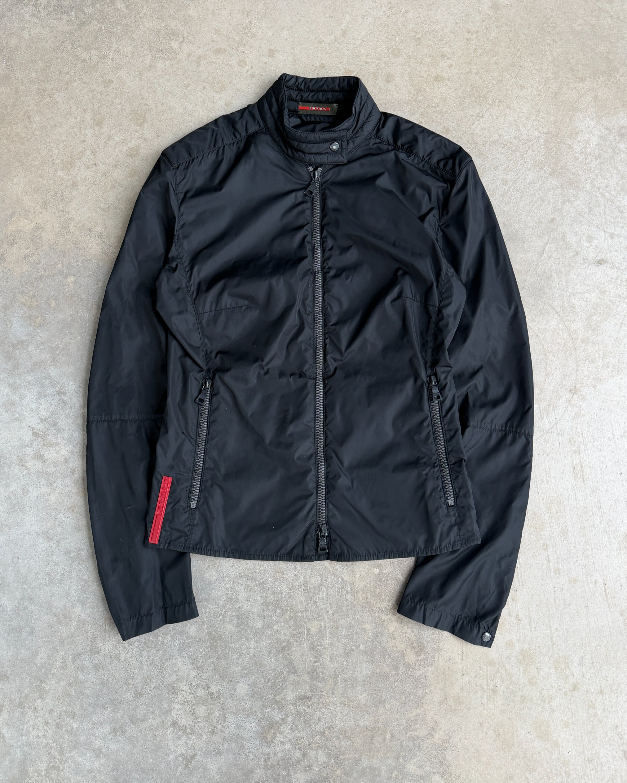 Prada SS99 Nylon Jacket with Elbow Patches – M-on a concrete background