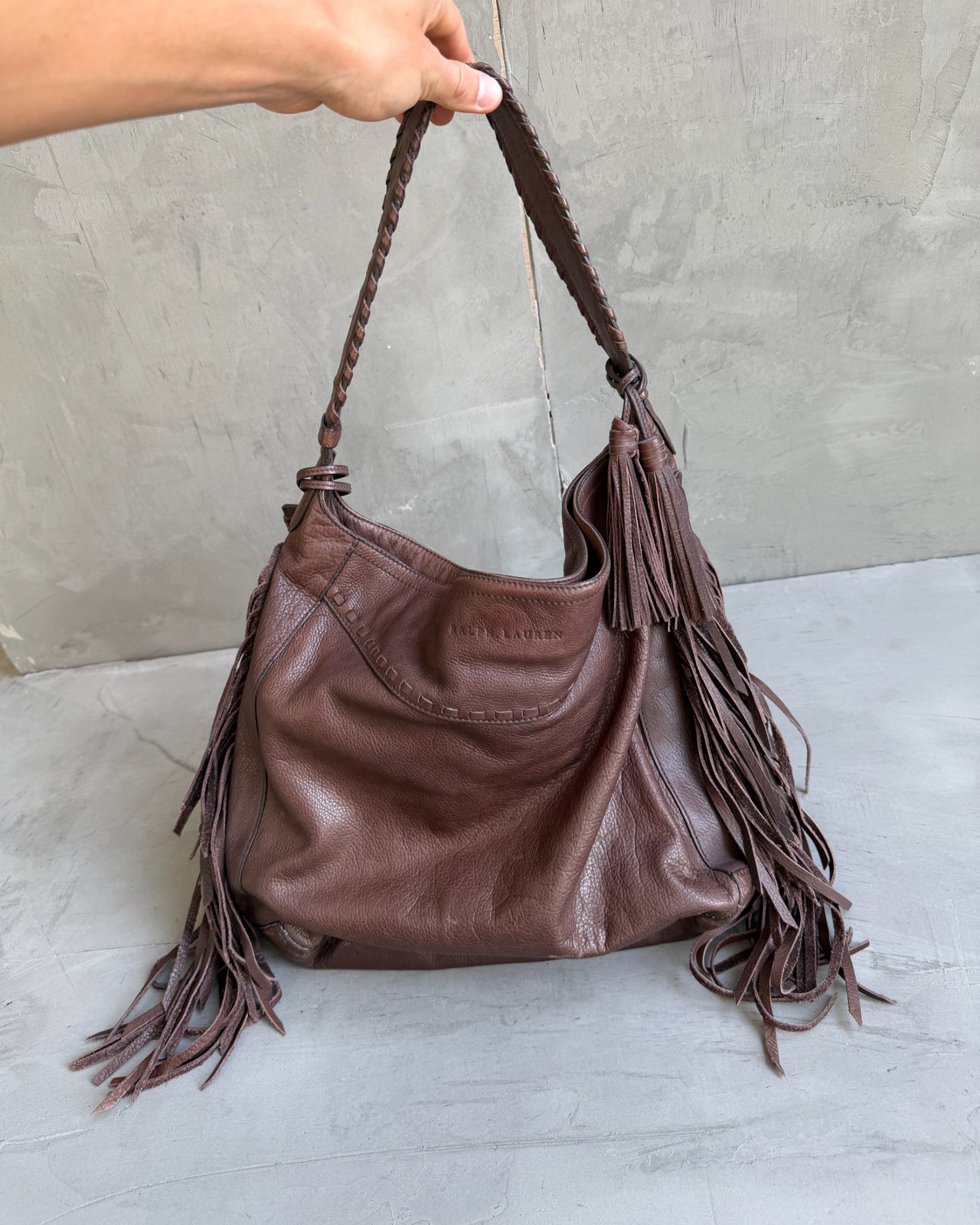 Ralph Lauren Brown Leather Fringe Shoulder Bag-on a concrete background
